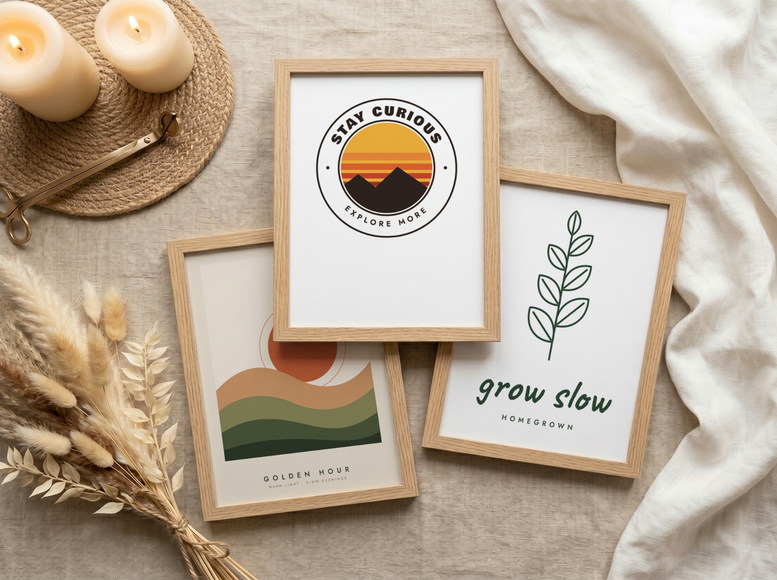 Flat lay mockup with three oak frames on linen, each smart object filled with a different print: a stay curious badge, a golden hour sunset and a botanical grow slow print