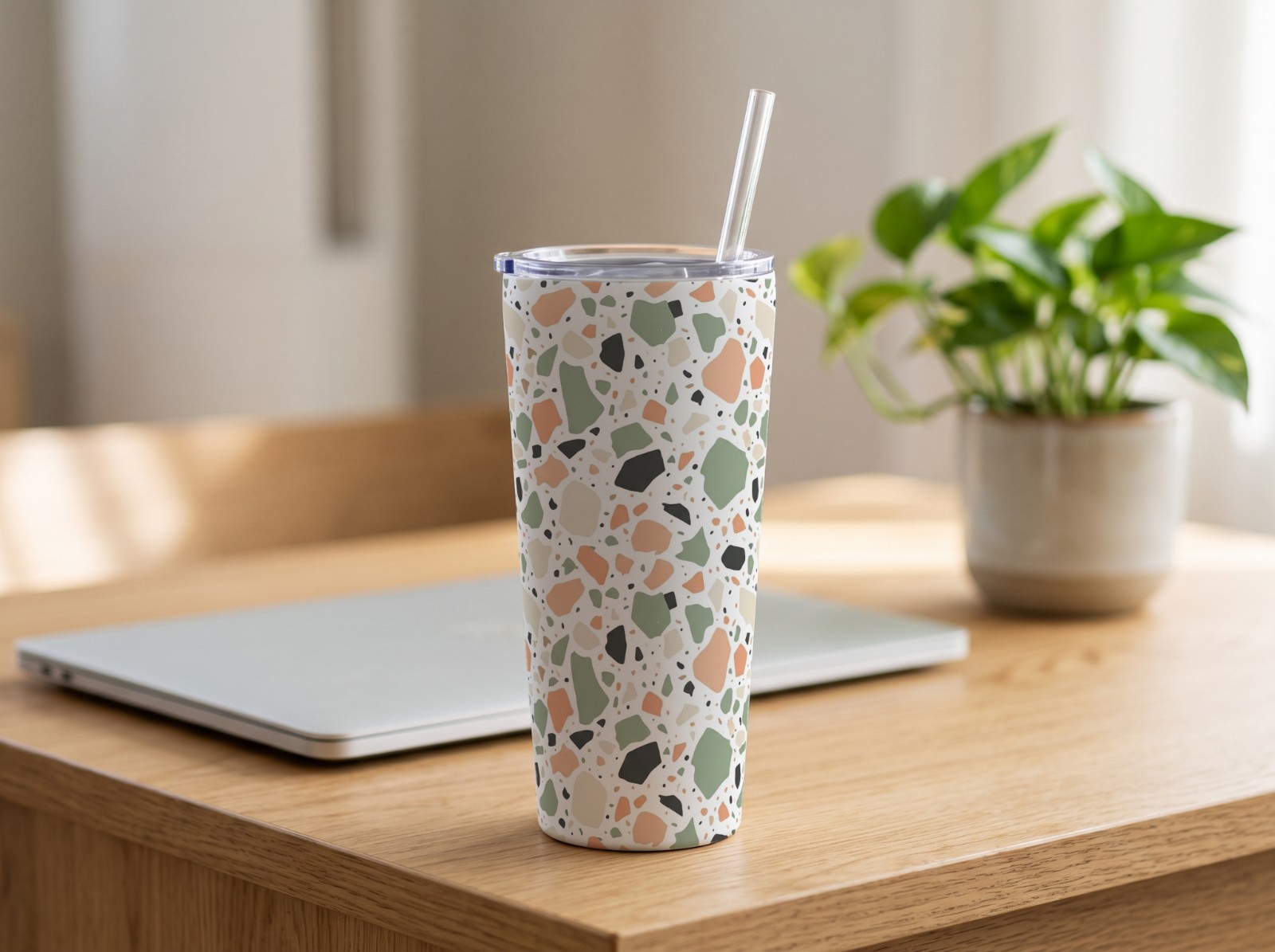 20 oz Tapered Tumbler on an Oak Desk with a Plant showing a pastel terrazzo pattern