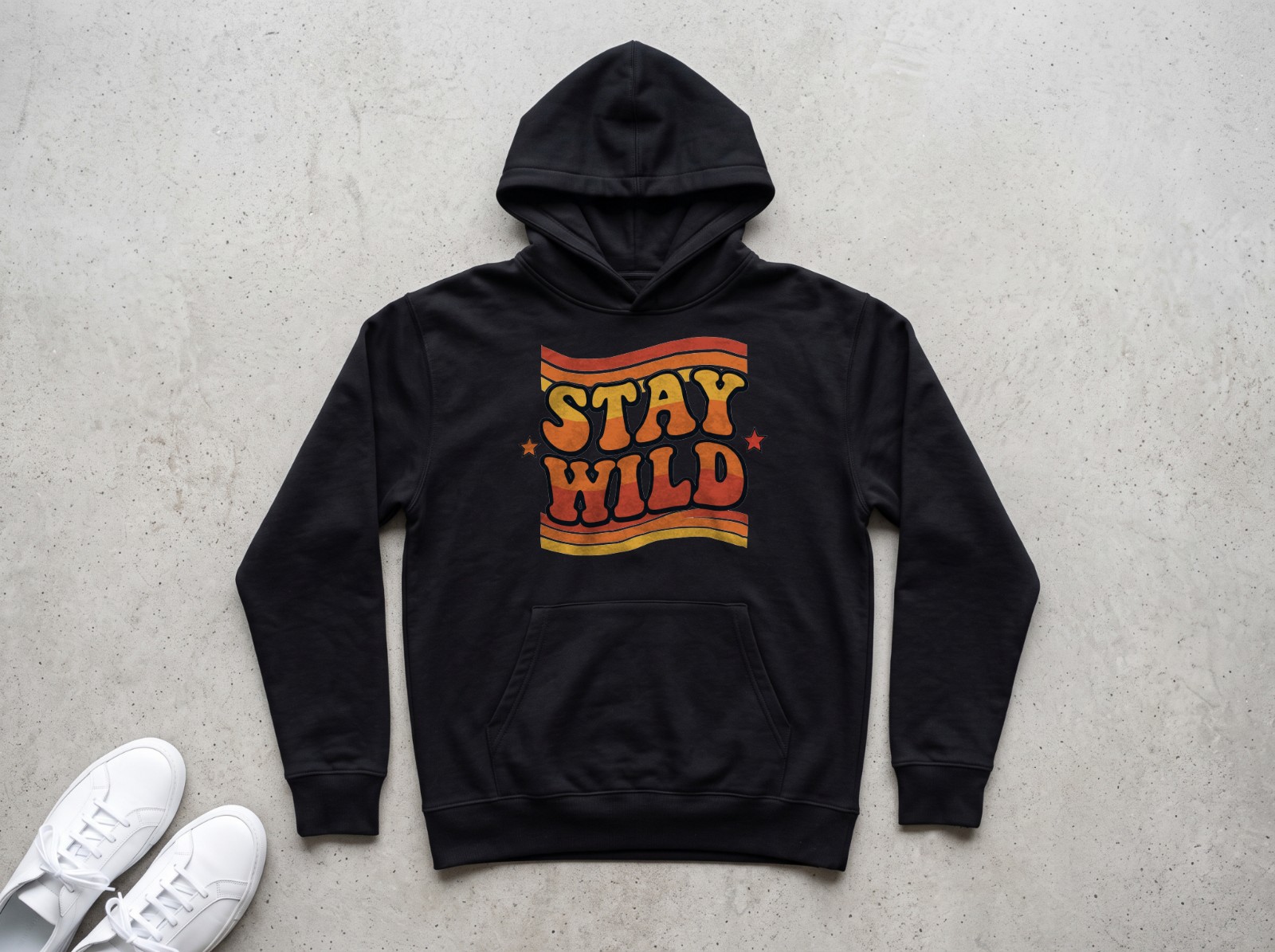 Black Hoodie Flat Lay on Concrete showing the retro Stay Wild design