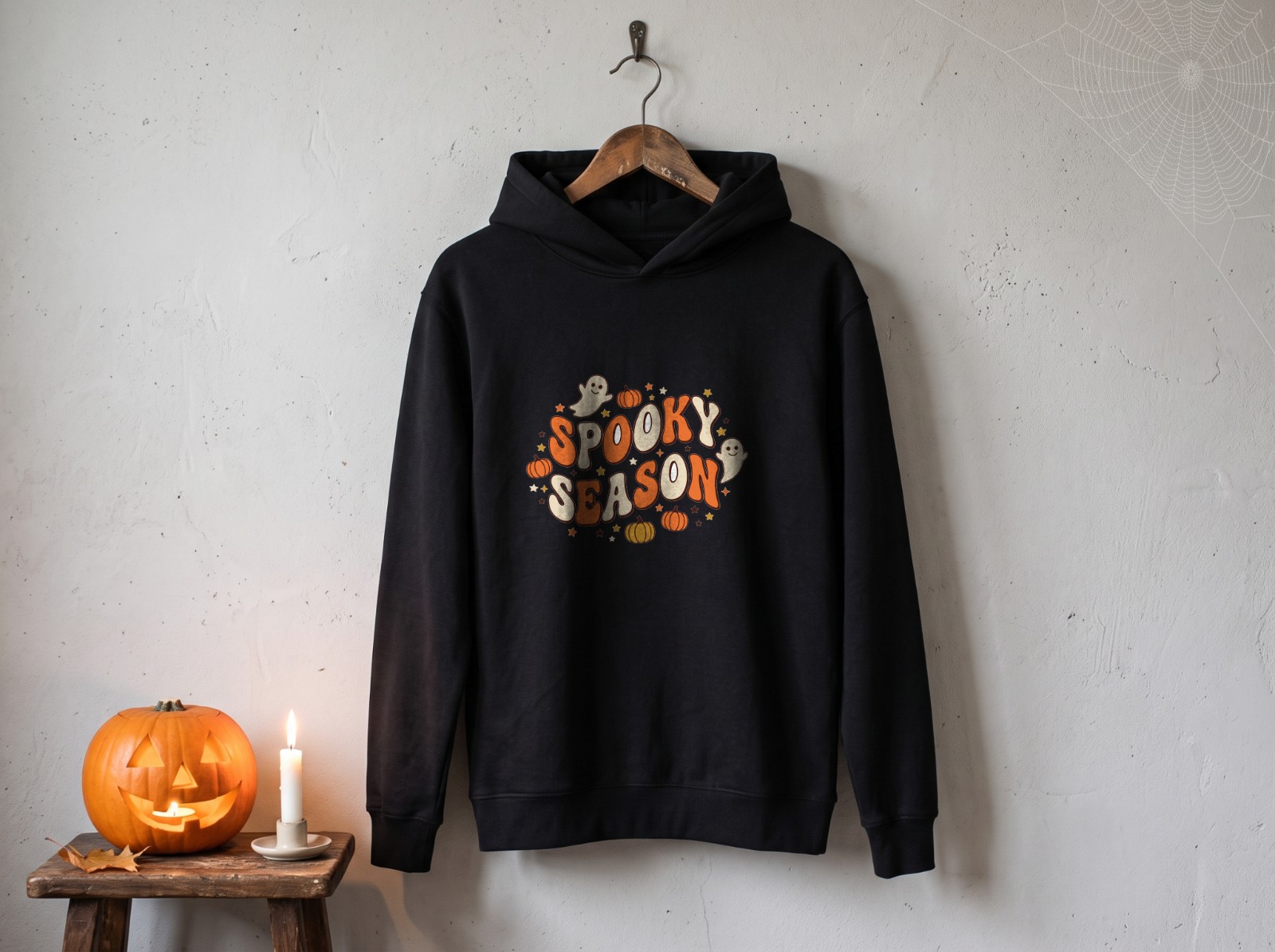 Black Hoodie Halloween Mockup on a Hanger with Cobweb and Jack-o'-Lantern example