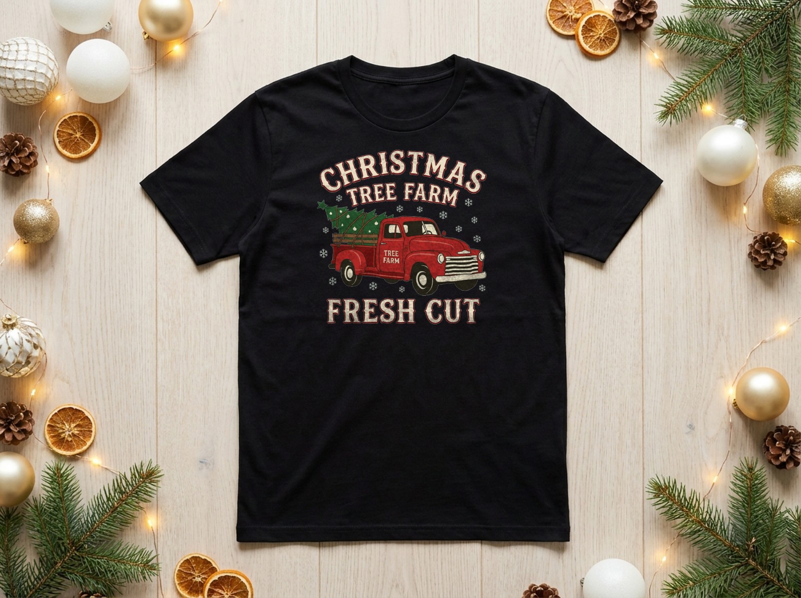 Black T-Shirt Christmas Flat Lay with Gold Baubles and Dried Oranges showing a vintage Christmas tree farm truck design