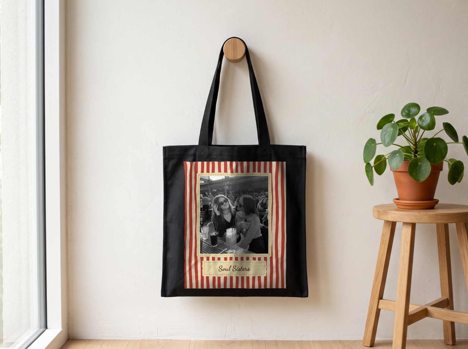 Black Tote Bag on a Wooden Wall Peg showing a retro Soul Sisters photo print