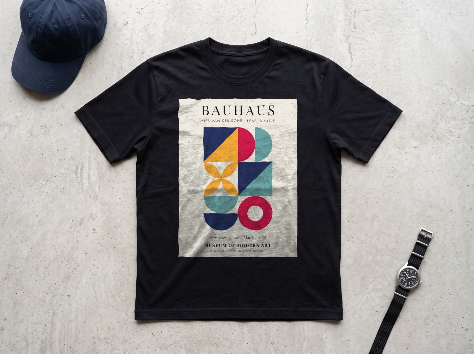 Black T-Shirt Flat Lay on Concrete showing a Bauhaus Less is More print