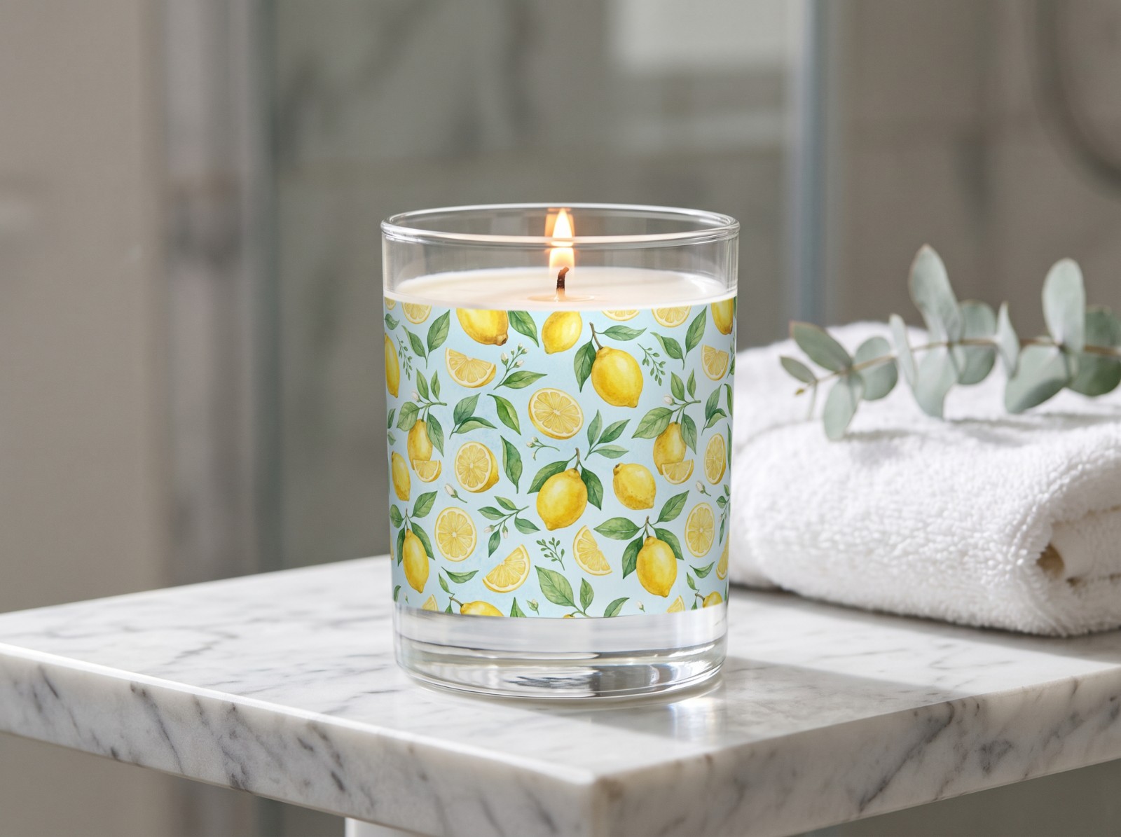 Clear Glass Candle on a Marble Bathroom Shelf showing a watercolour lemon pattern label