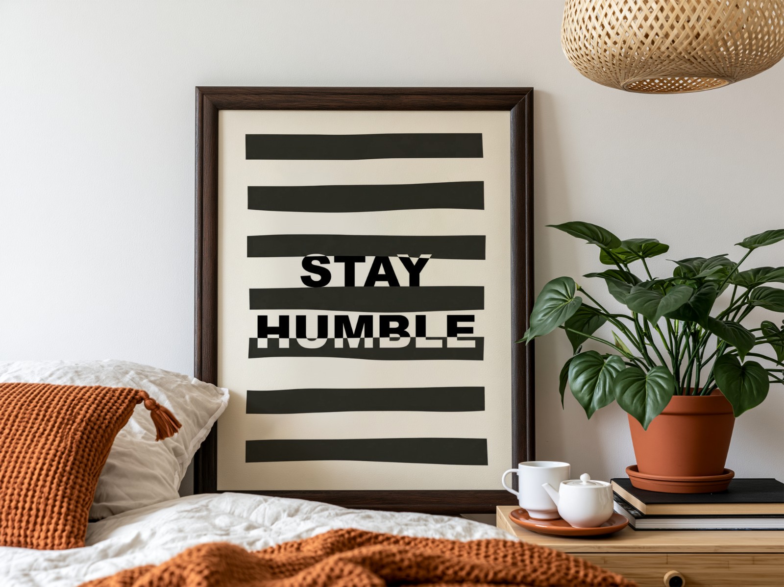 Dark Wood Frame Above Bed with Plant showing a Stay Humble typography print