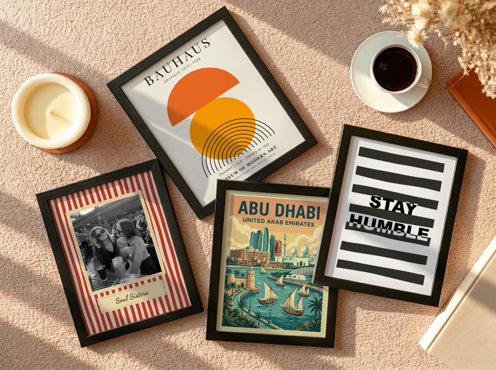 Four Black Frames Flat Lay on Beige Carpet showing a Stay Humble typography print, a retro Soul Sisters print and 2 more designs