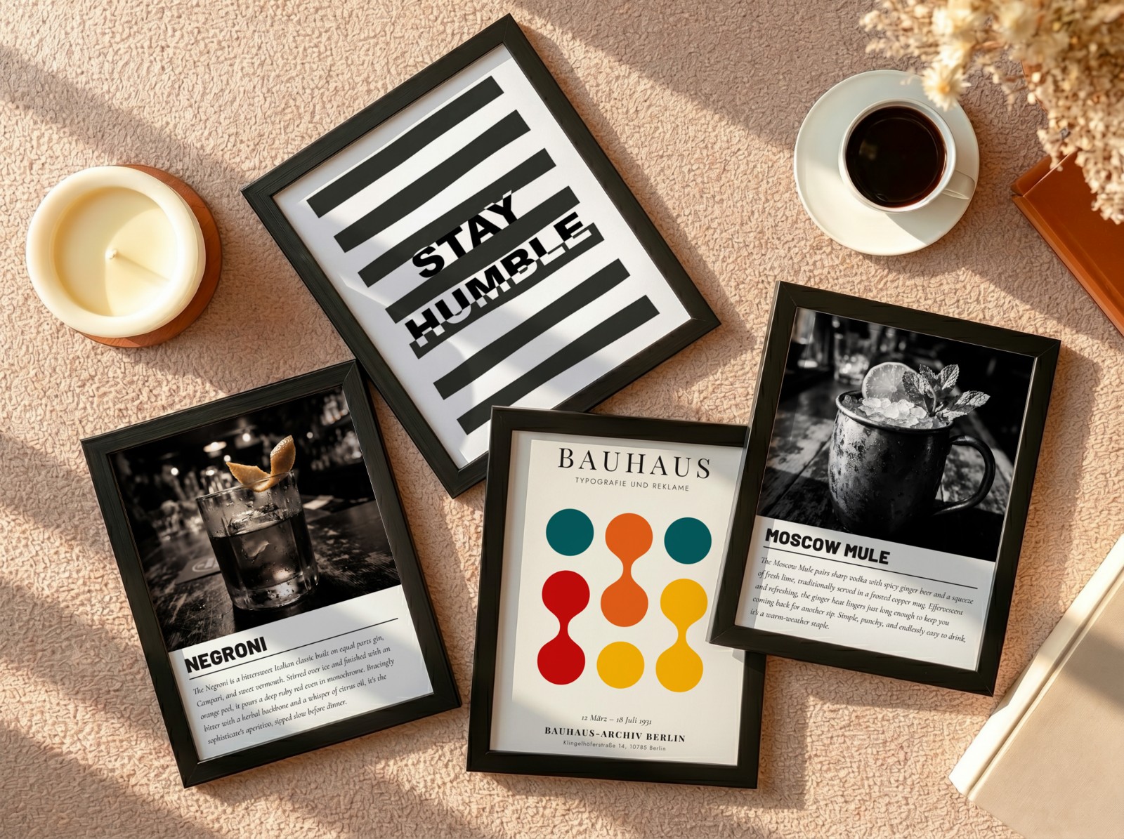 Four Black Frames Flat Lay on Beige Carpet showing a Moscow Mule cocktail print, a Negroni cocktail print and 2 more designs