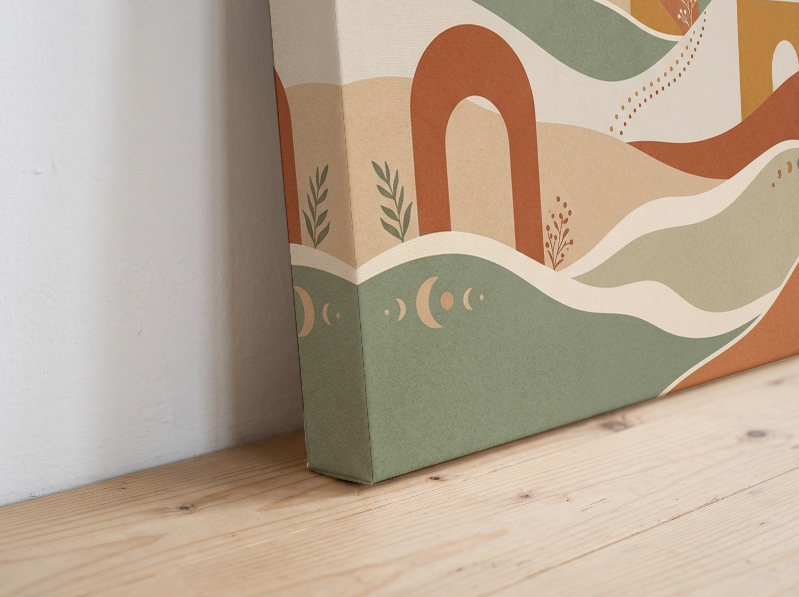 Corner close-up of a mirror edge canvas with a boho sun and arches print on a wooden floor