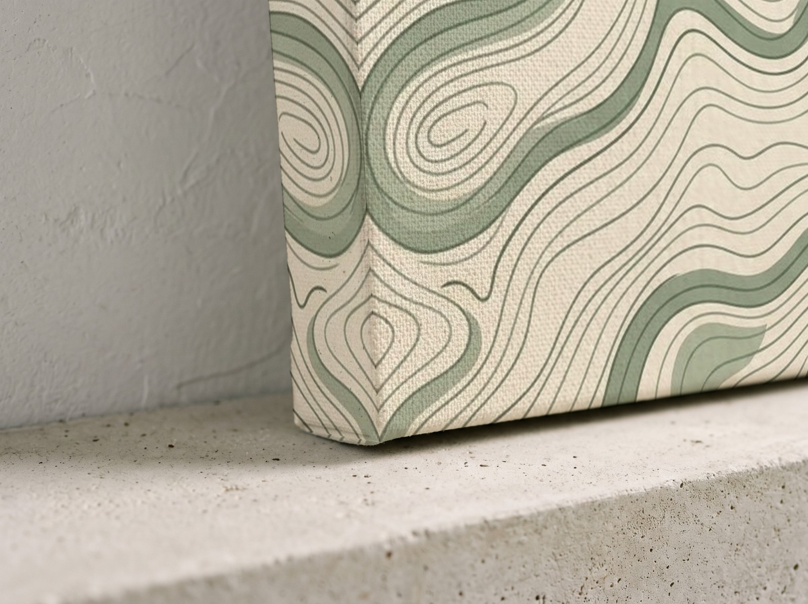 Corner close-up of a textured mirror edge canvas with a sage topographic print on a concrete shelf