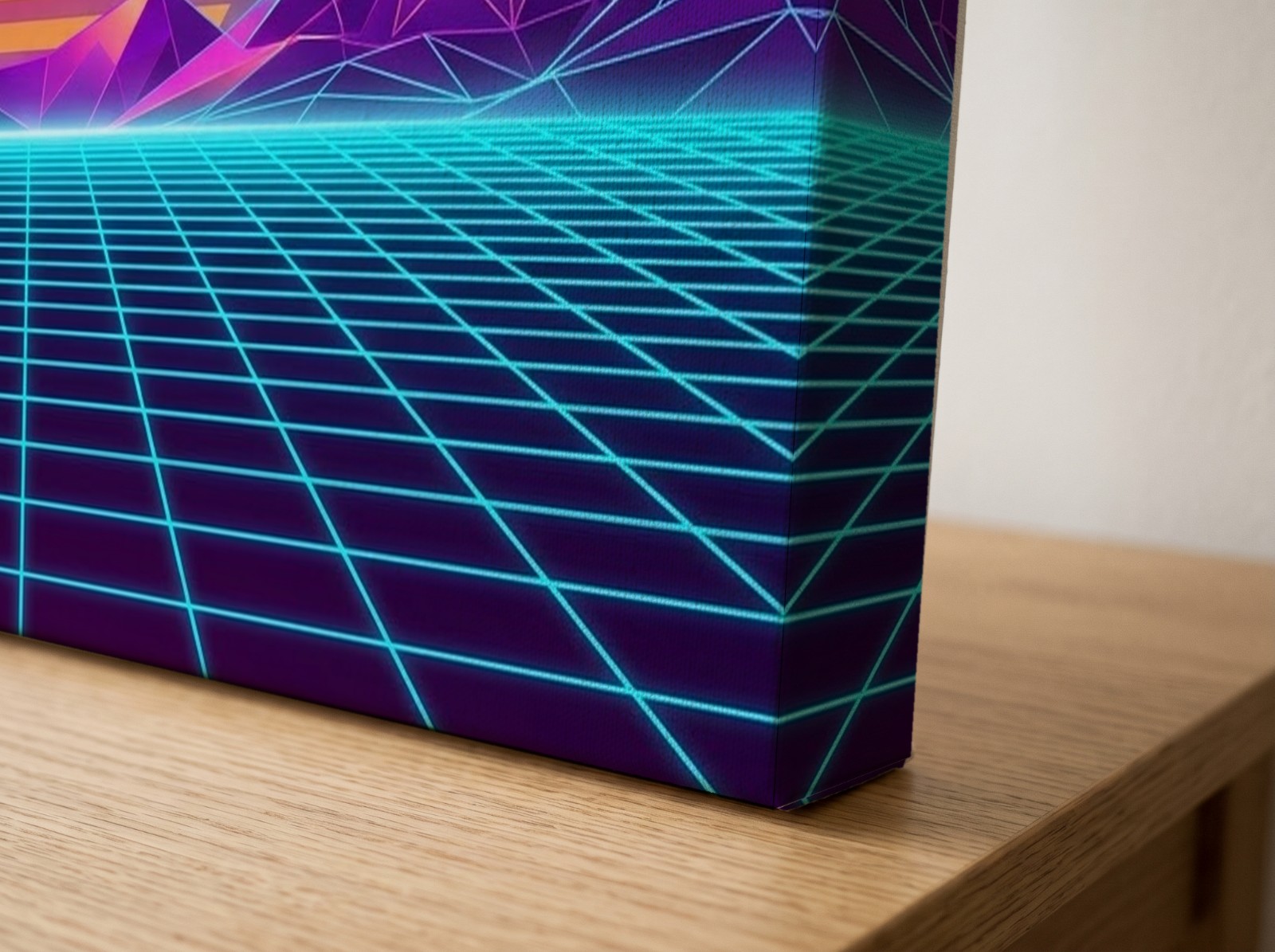 Corner close-up of a textured mirror edge canvas with a neon synthwave print on an oak table