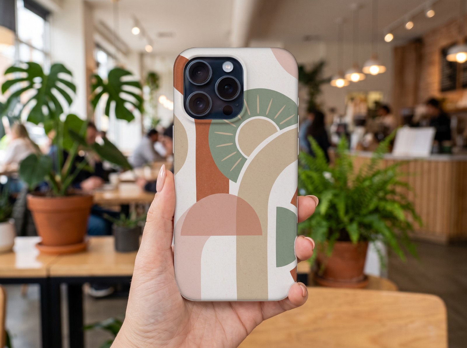 iPhone 15 Pro Case Mockup Held in a Hand in a Café example
