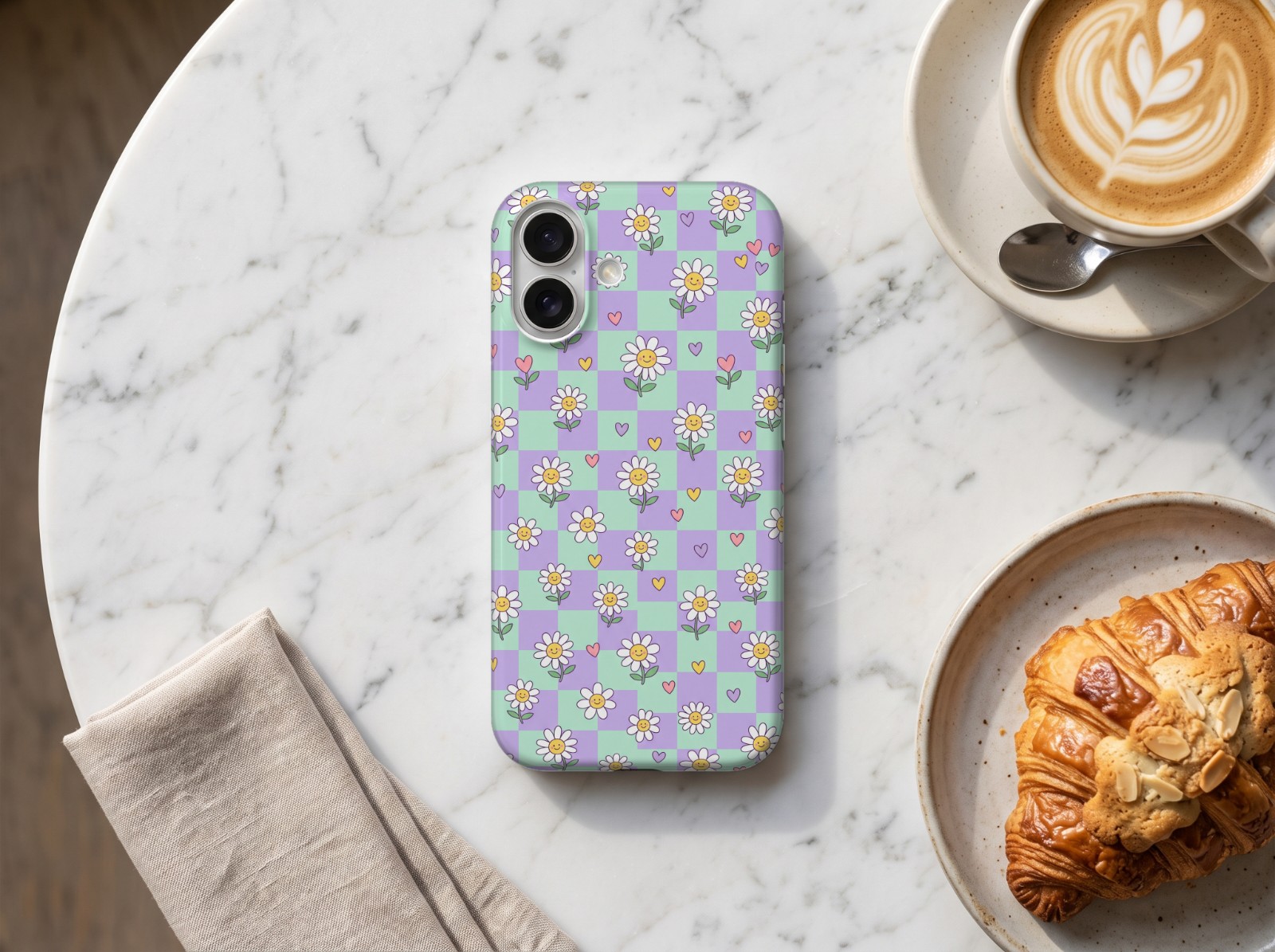iPhone 16 Case on a Marble Café Table showing a pastel checkerboard daisy print