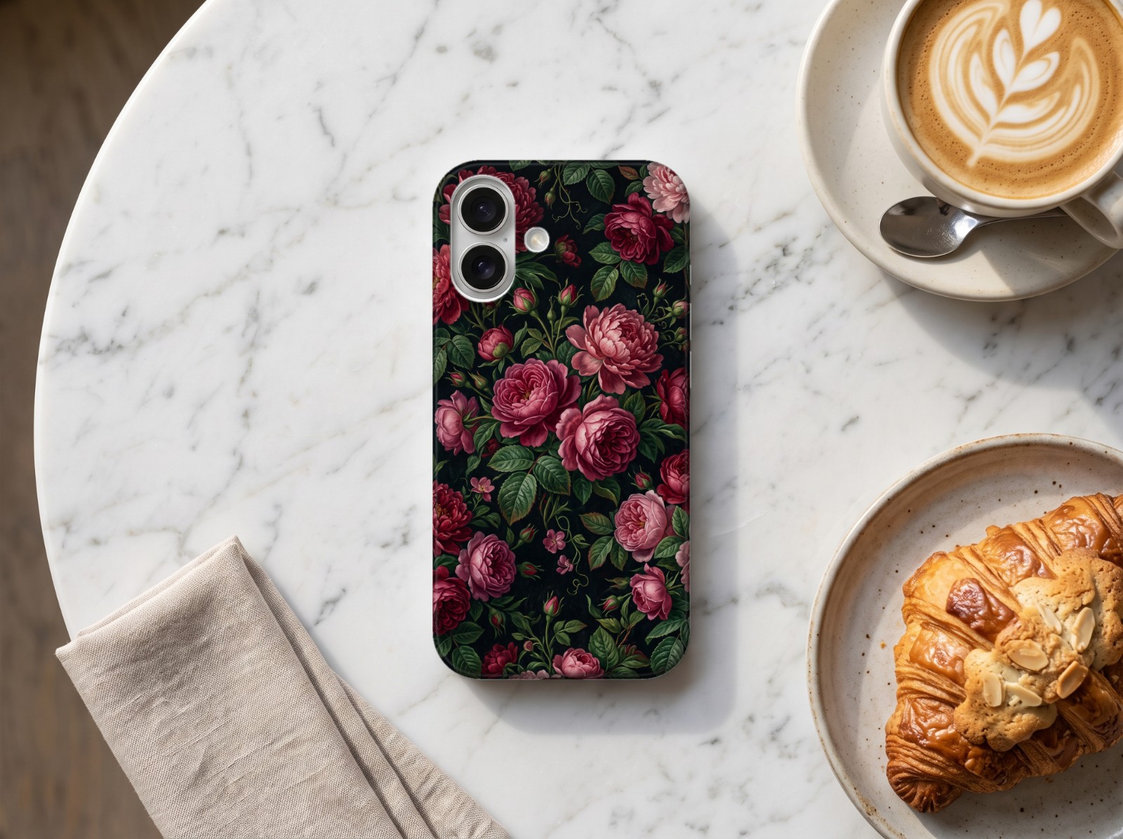 iPhone 16 Case on a Marble Café Table showing a dark moody floral print