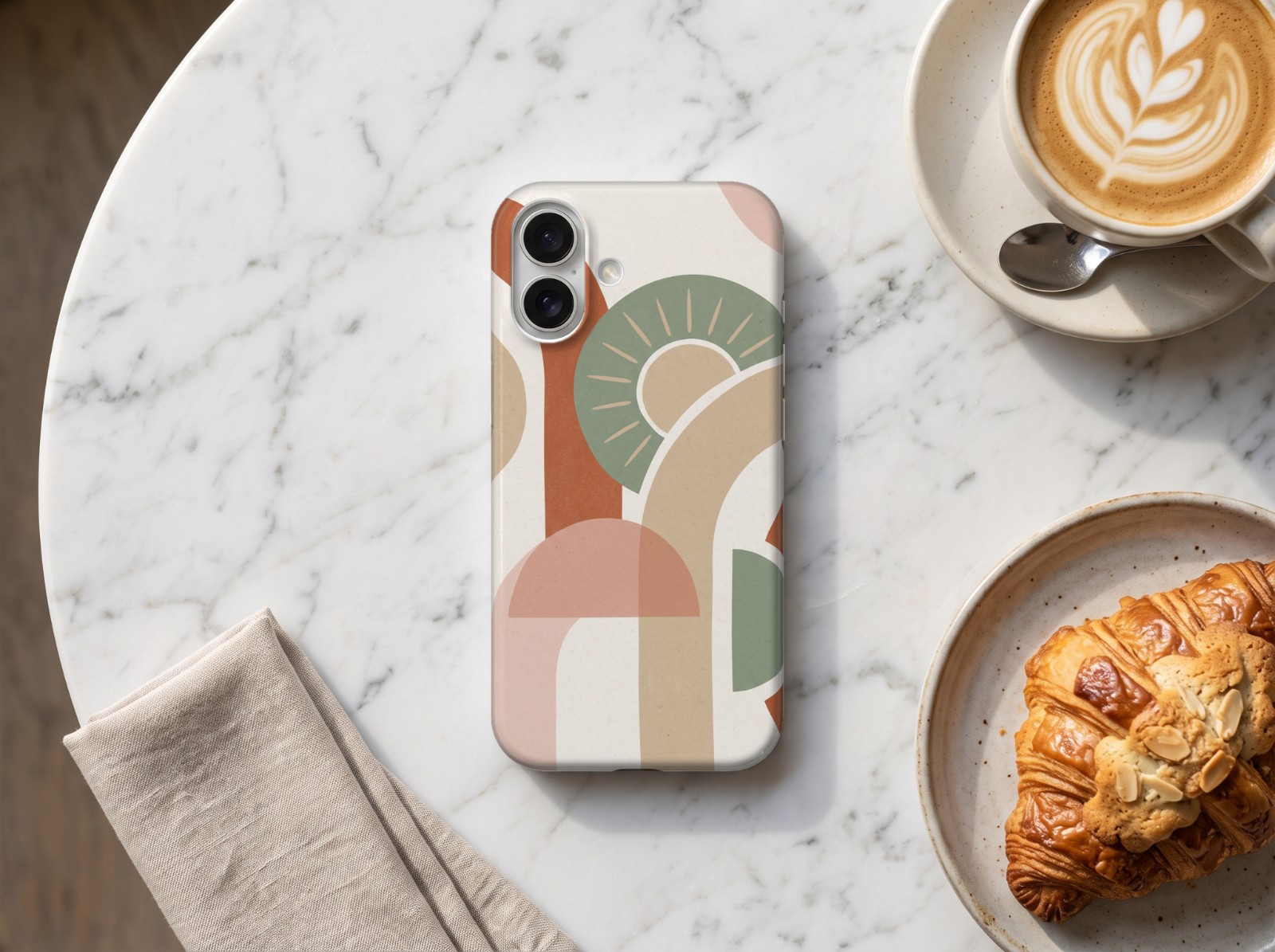iPhone 16 Case on a Marble Café Table showing a boho arches print