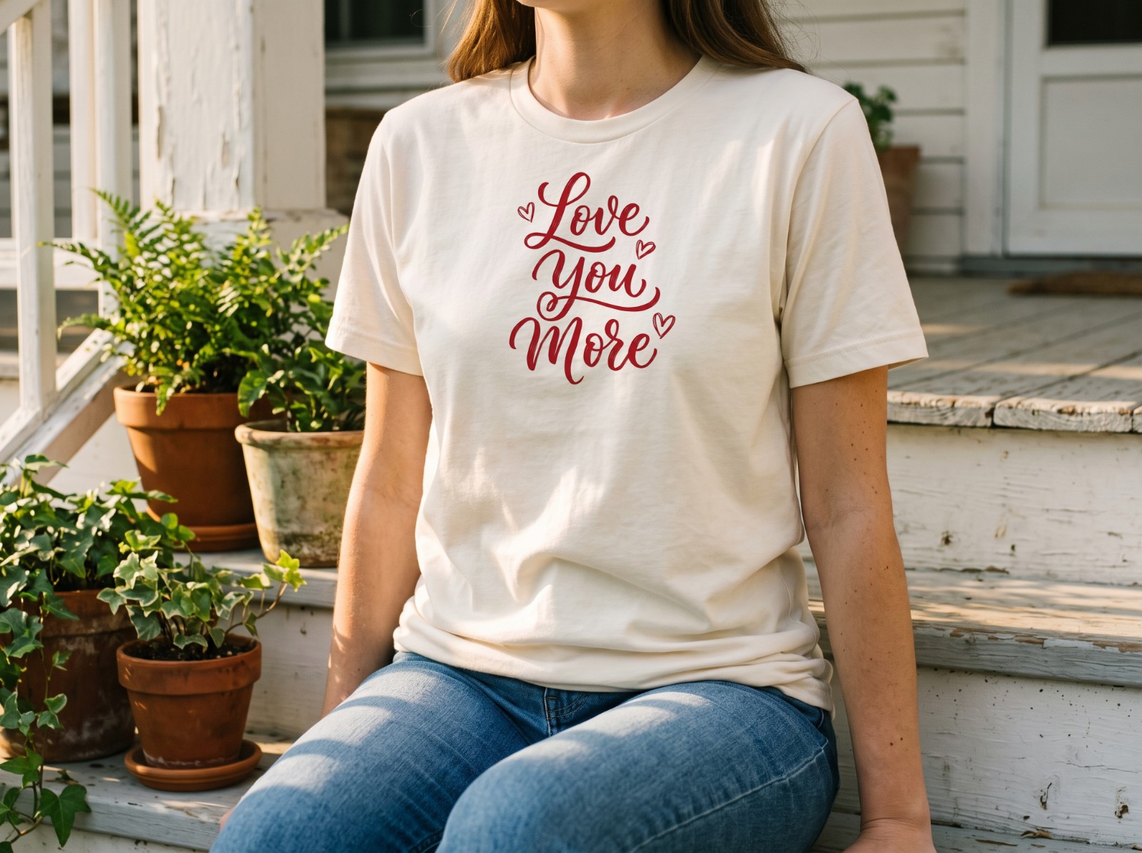 Natural T-Shirt on a Woman Sitting on Porch Steps showing a Love You More lettering