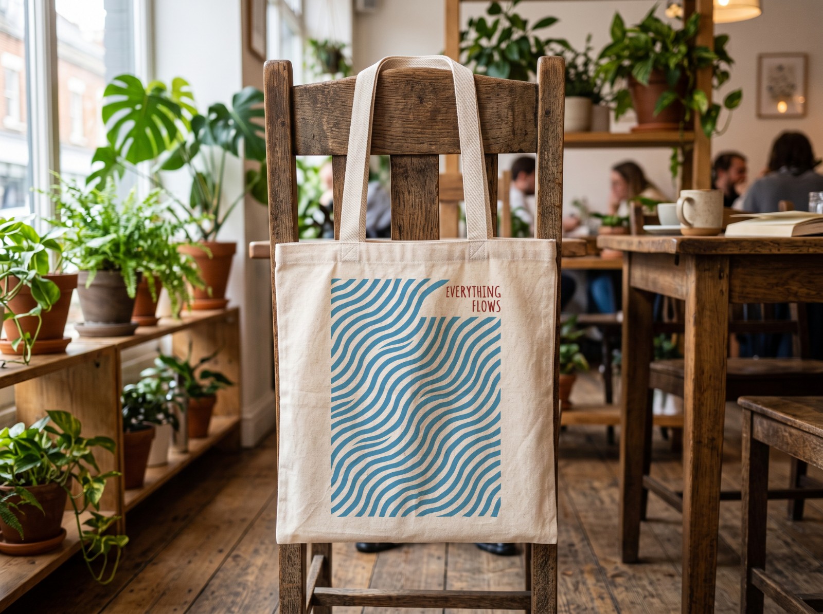 Natural Tote Bag on a Wooden Cafe Chair showing an Everything Flows wave print