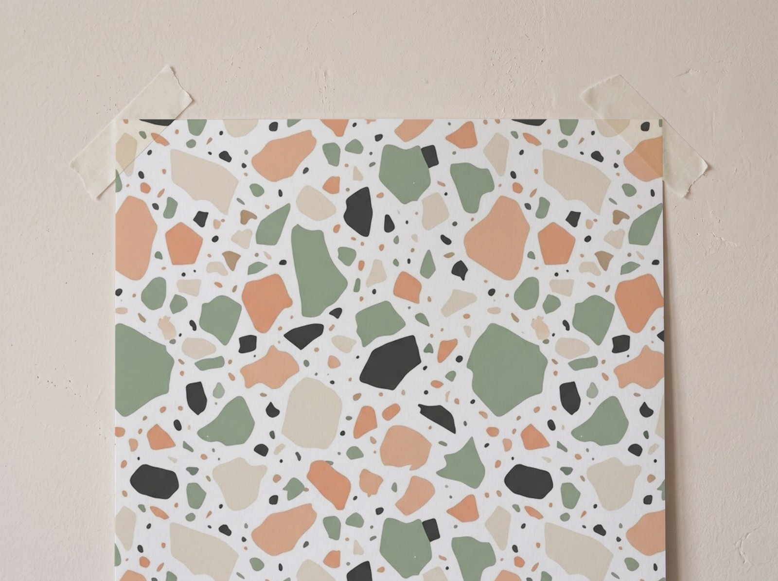 Close-up of a taped poster with a terrazzo pattern print on a plaster wall