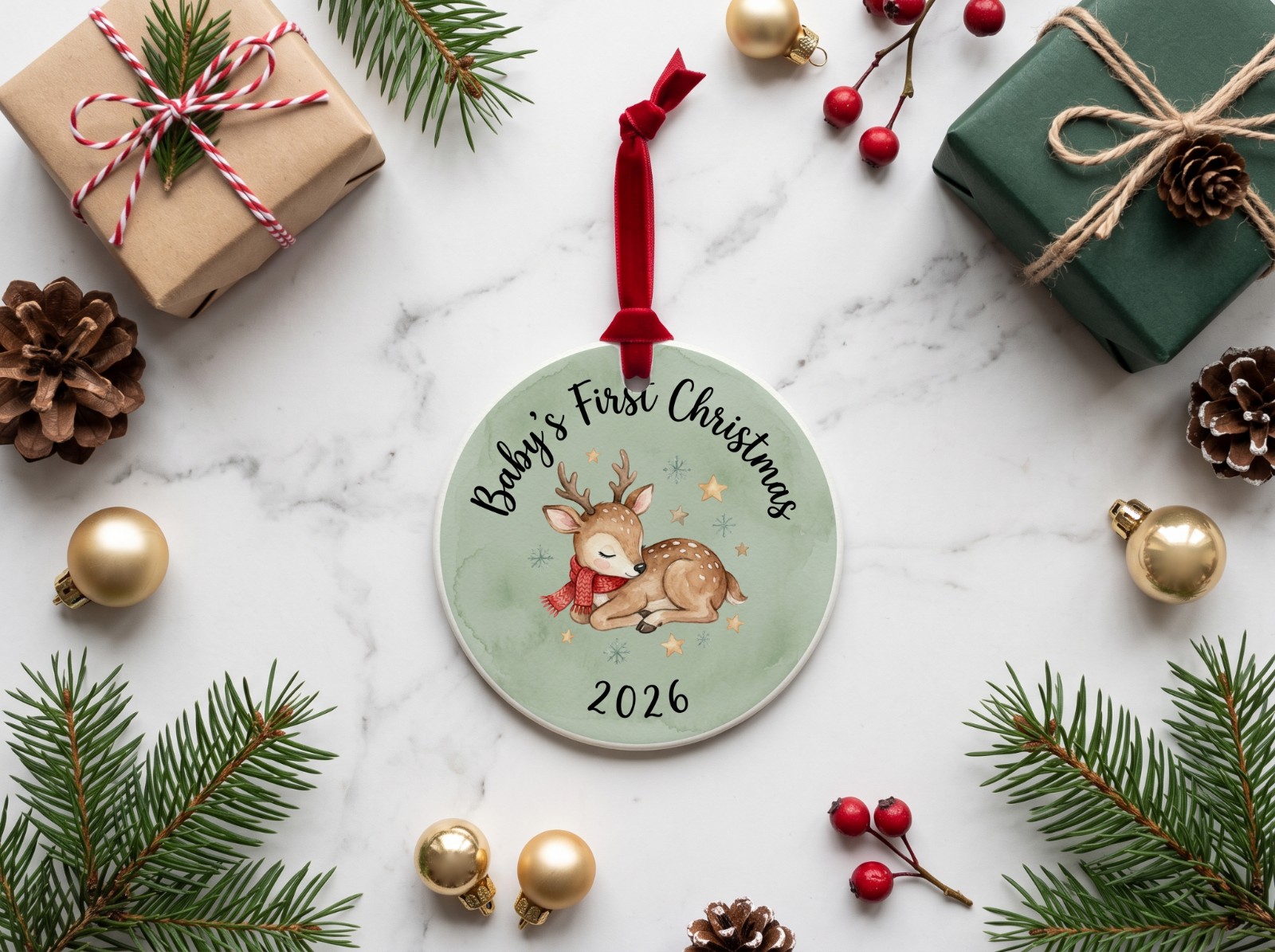 Round Ceramic Christmas Ornament on Marble with Gift Boxes showing a Baby's First Christmas reindeer design