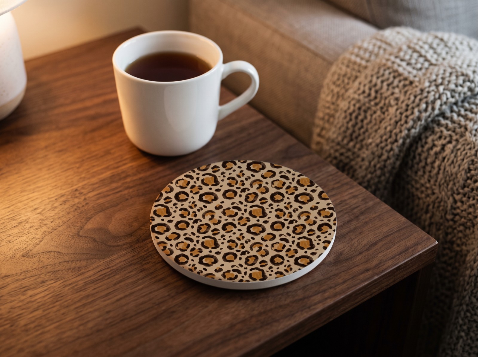 Round Sandstone Coaster on a Walnut Side Table with Tea showing a neutral leopard print