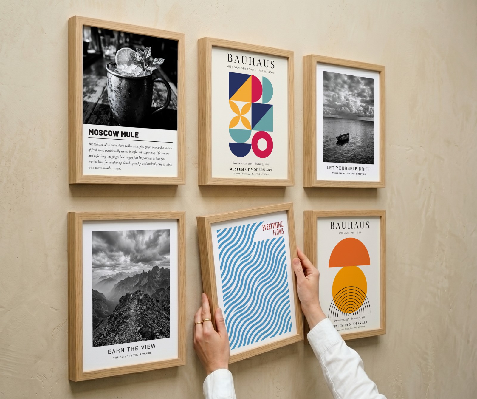 Six Oak Frame Gallery Wall, Angle View showing a Bauhaus sun print, an Everything Flows wave print and 4 more designs