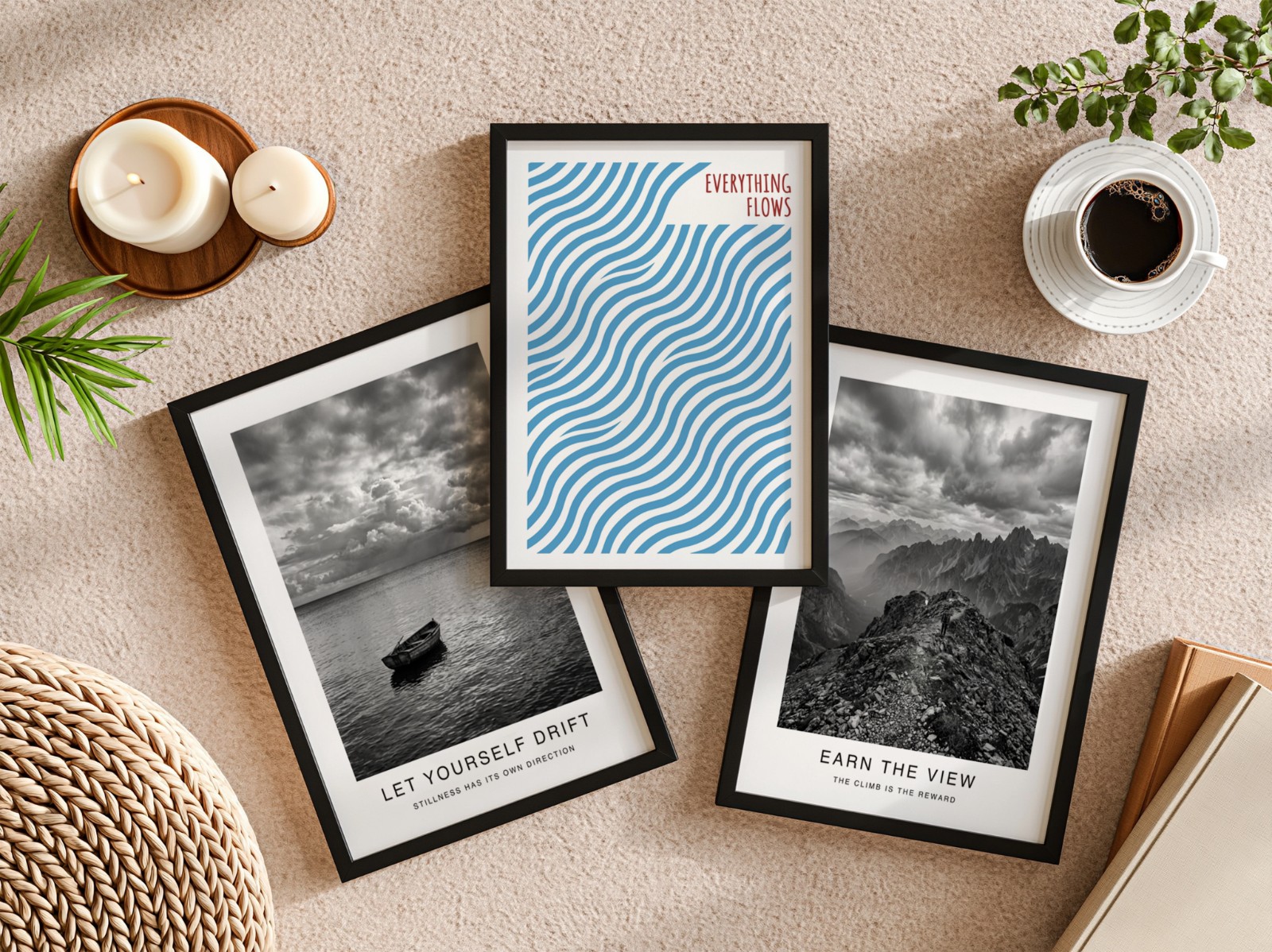 Three Black Frames Flat Lay on Beige Carpet showing an Everything Flows wave print, a black and white mountain print and 1 more design