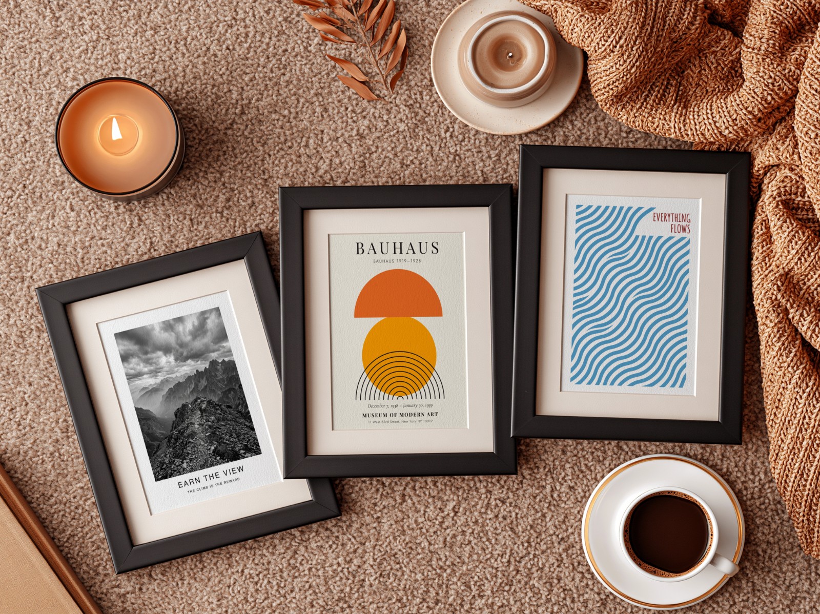 Three Black Frames with Mats on Rust Rug showing a Bauhaus sun print, an Everything Flows wave print and 1 more design