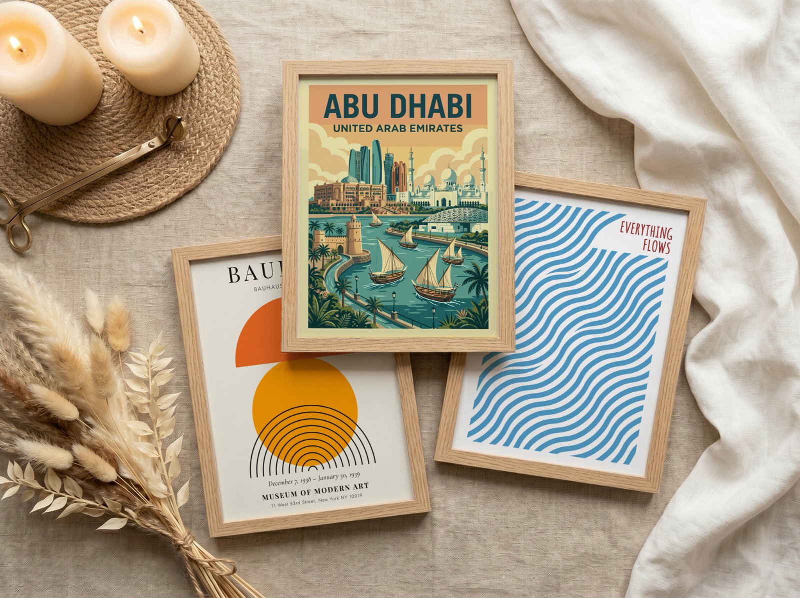Three Oak Frames Flat Lay on Linen showing an Abu Dhabi travel poster, a Bauhaus sun print and 1 more design