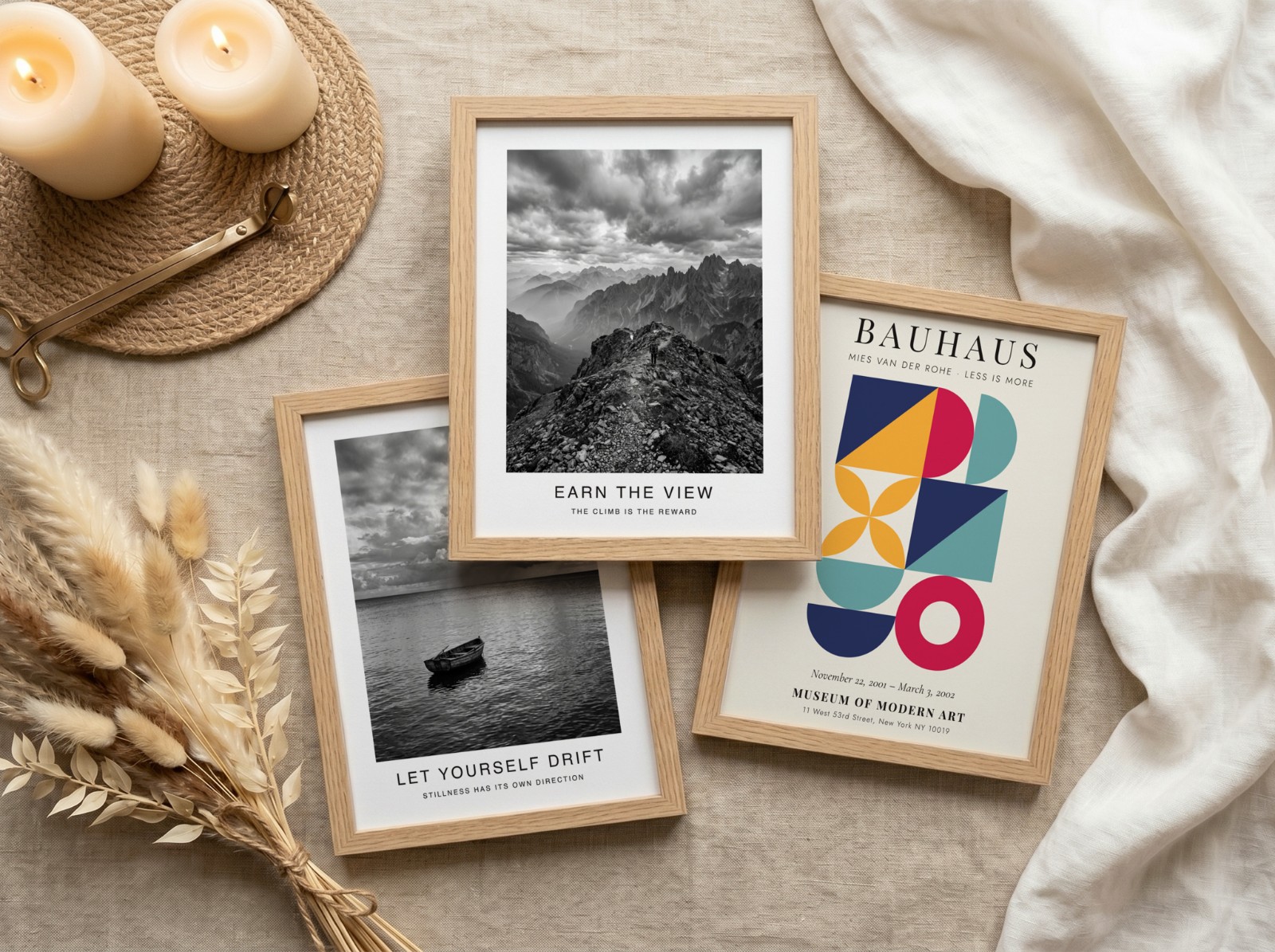 Three Oak Frames Flat Lay on Linen showing a black and white mountain print, a black and white seascape print and 1 more design