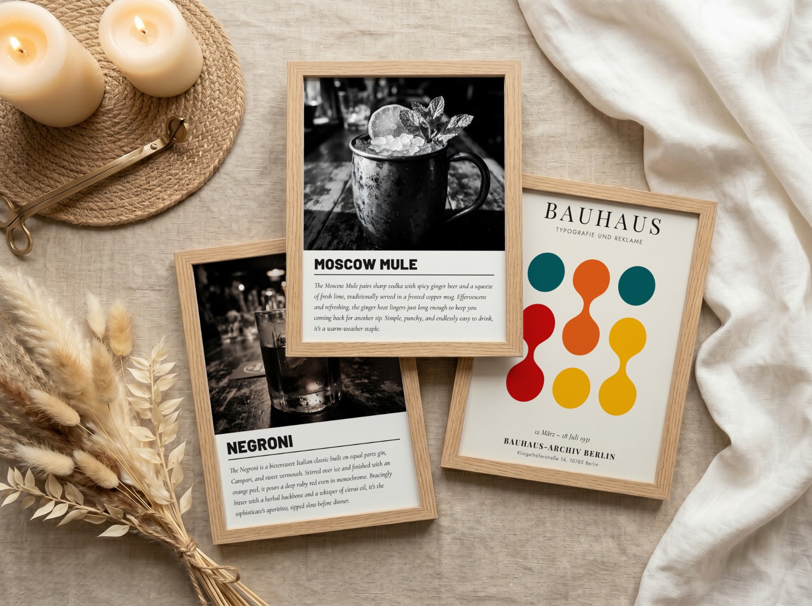 Three Oak Frames Flat Lay on Linen showing a Moscow Mule cocktail print, a Negroni cocktail print and 1 more design