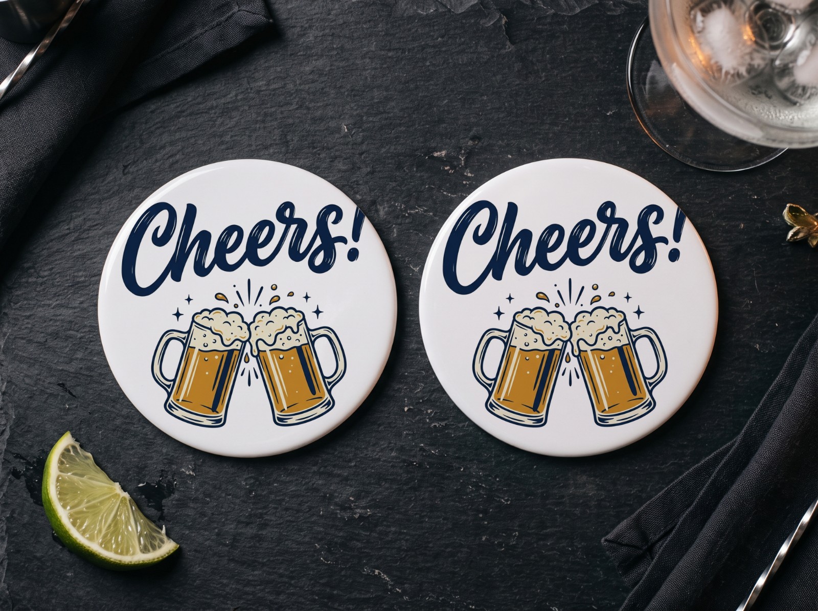 Two Round White Coasters on a Slate Bar showing a Cheers lettering design