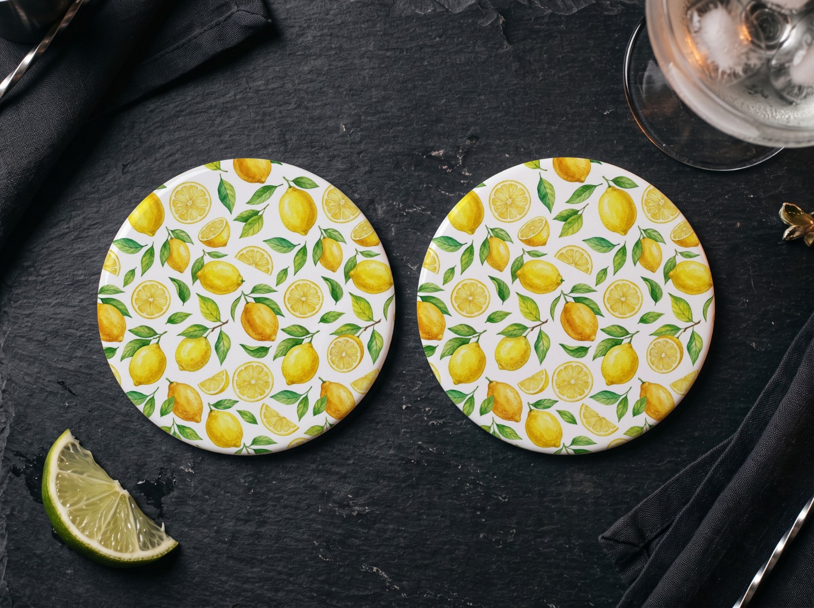 Two Round White Coasters on a Slate Bar showing a watercolour lemon pattern