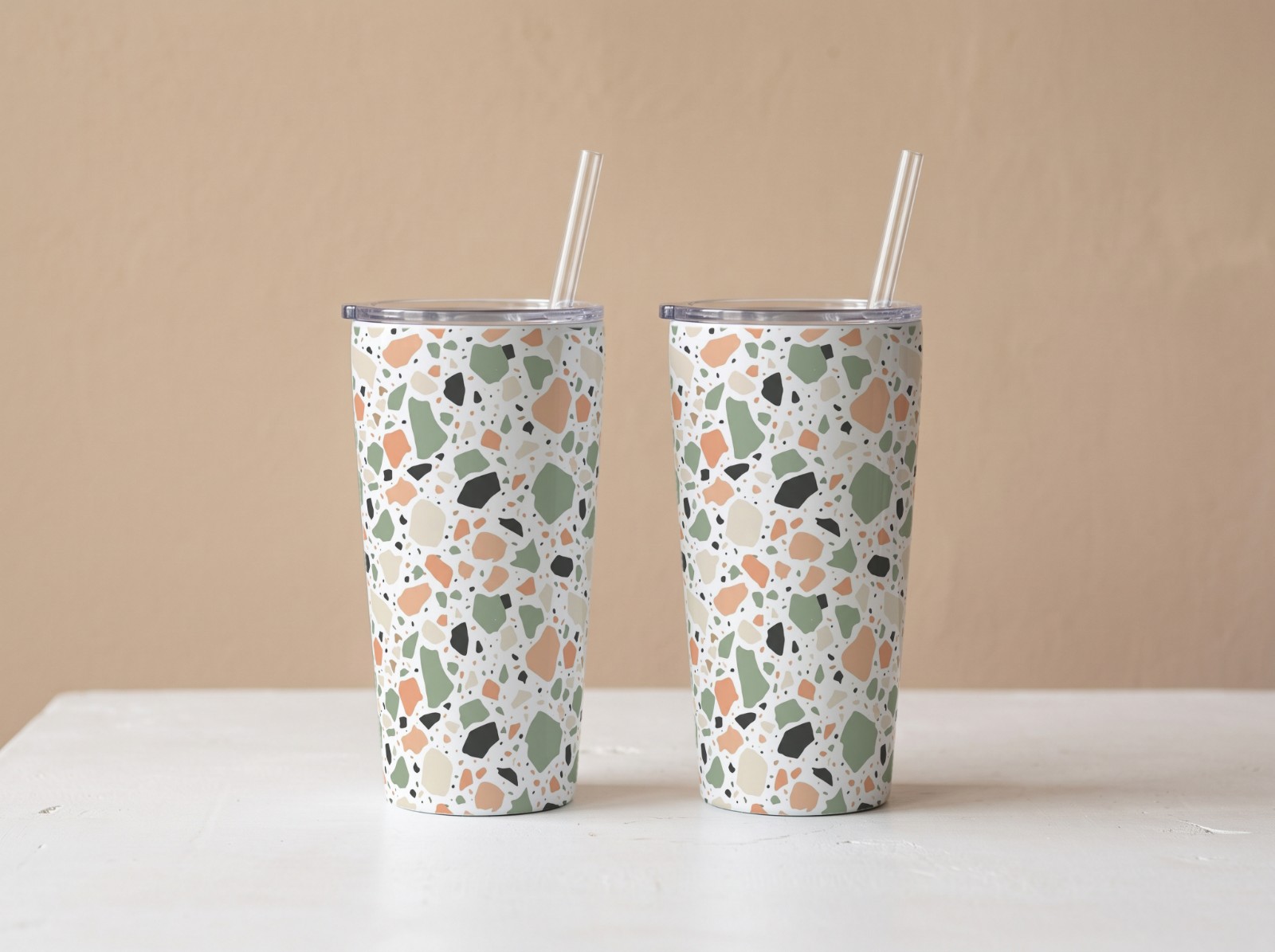 Two Tapered Tumblers Against a Beige Wall showing a pastel terrazzo pattern