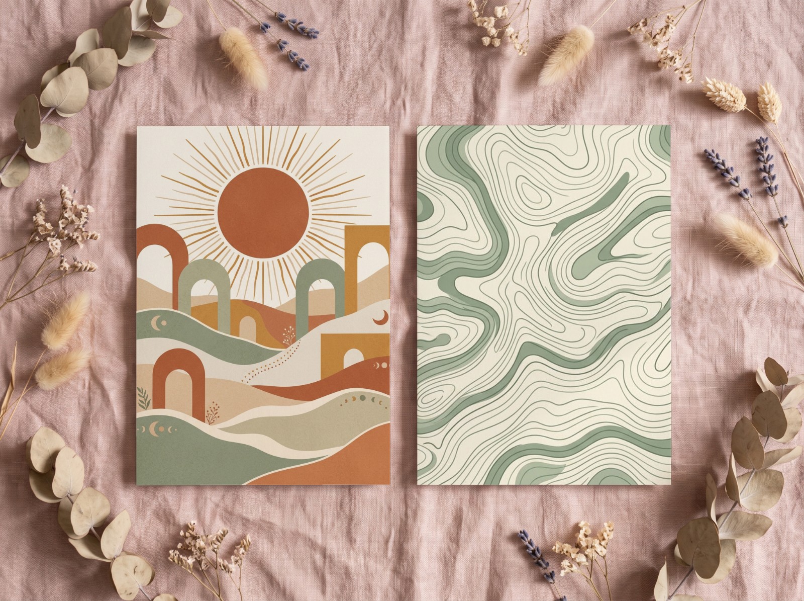 Two White Art Prints Flat Lay on Pink Linen with Dried Flowers showing a boho sun wall art and a sage topographic map pattern