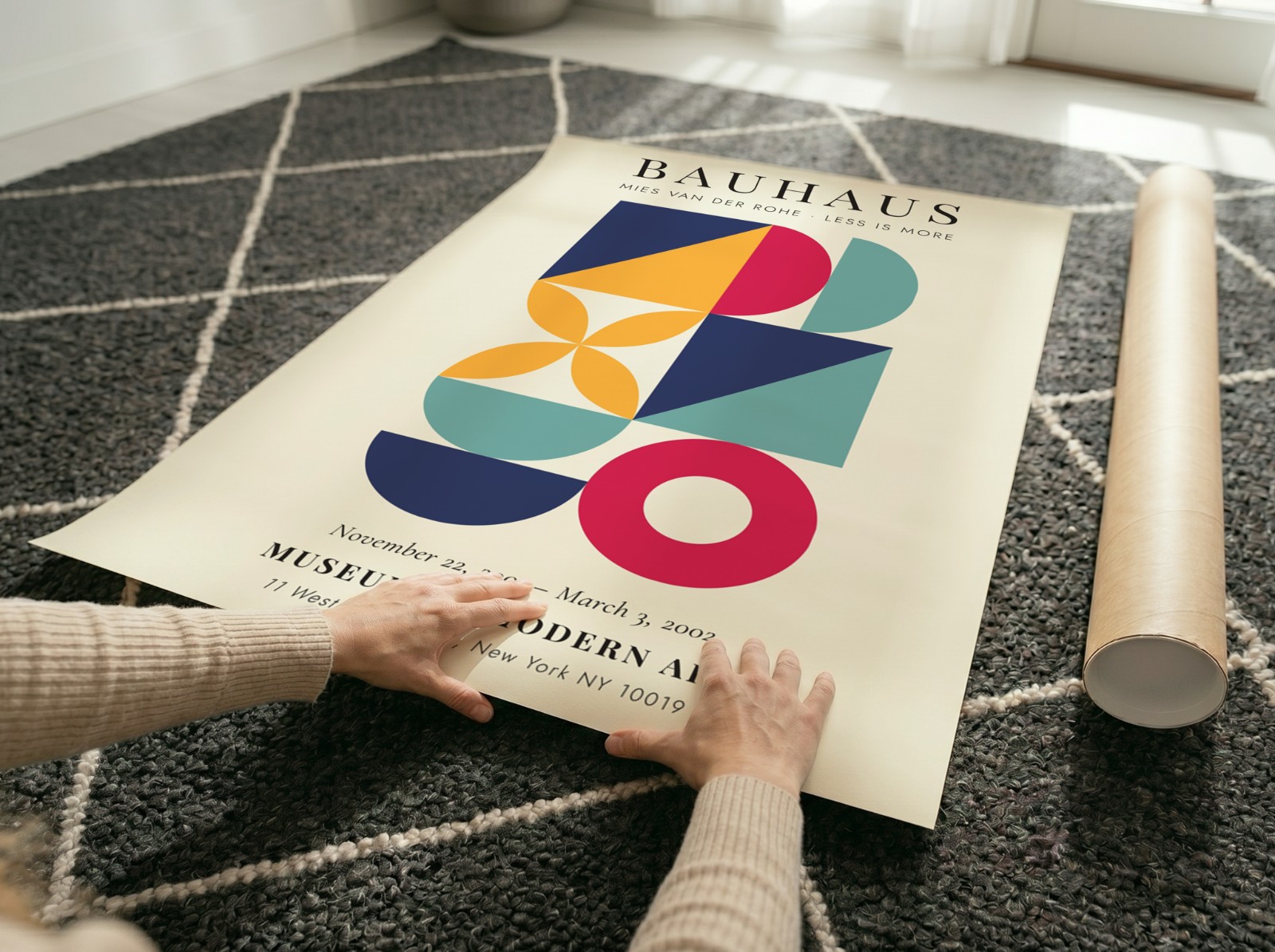 Unframed Poster Unrolling on Patterned Rug showing a Bauhaus geometric print