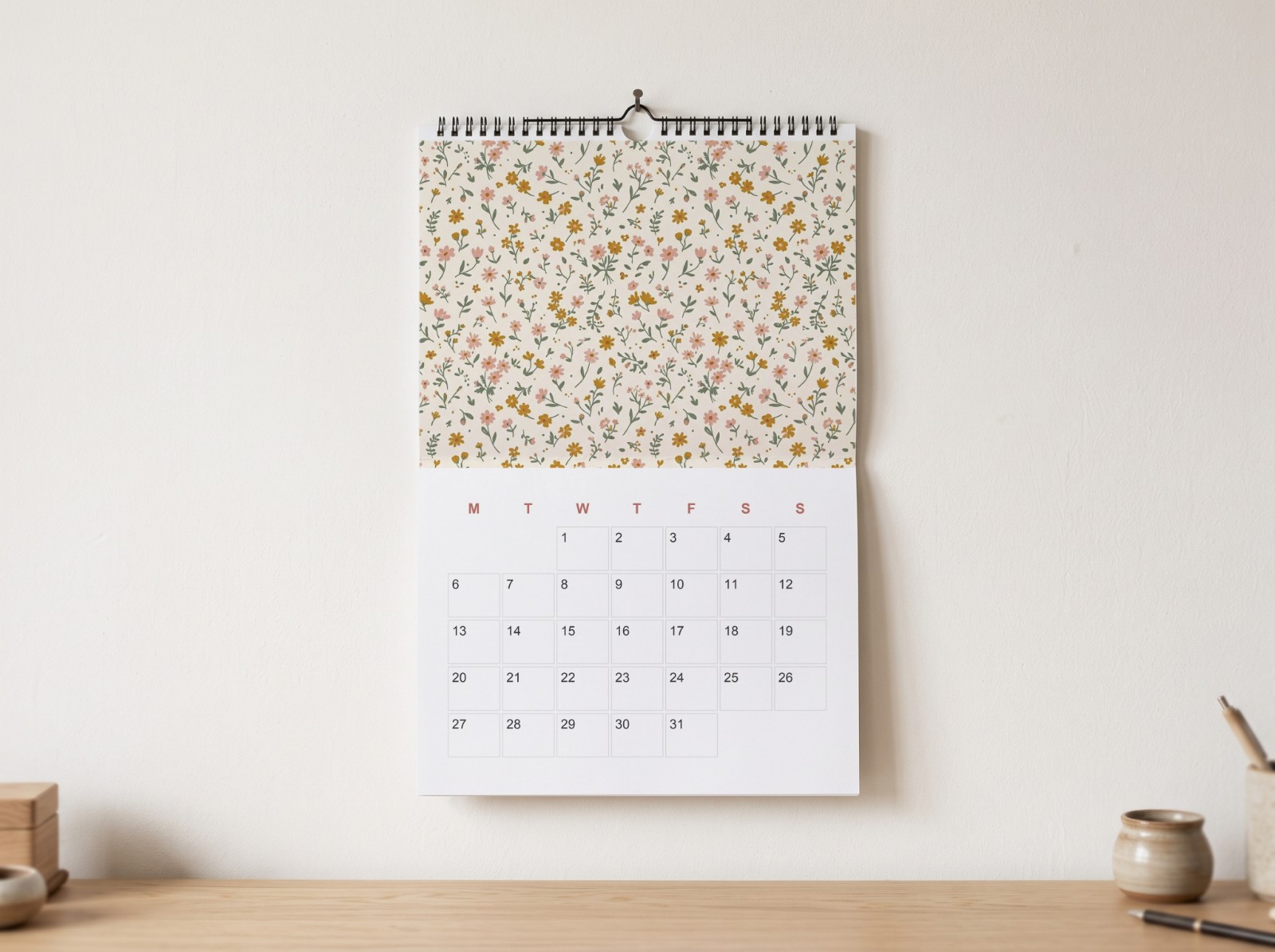Wall Calendar Hanging on a White Wall Above a Desk showing a floral calendar page