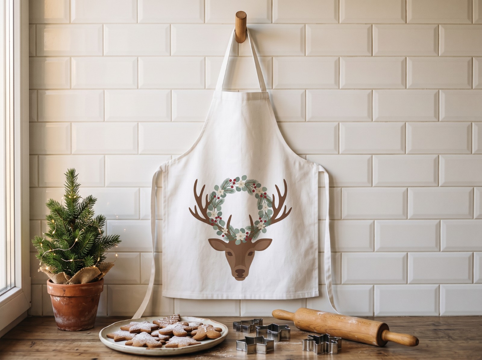 White Apron Christmas in a Baking Kitchen with Gingerbread showing a watercolour reindeer with a winter wreath