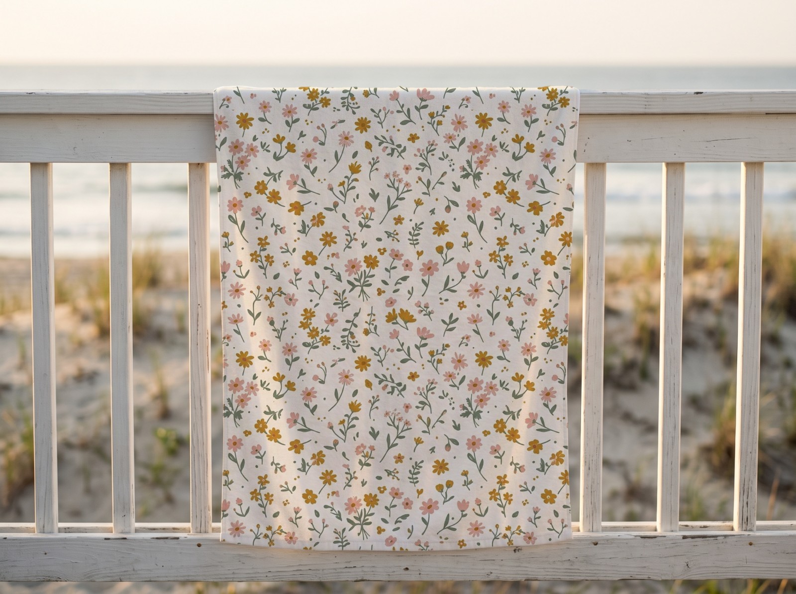 White Beach Towel on a Beach House Railing showing a ditsy wildflower pattern