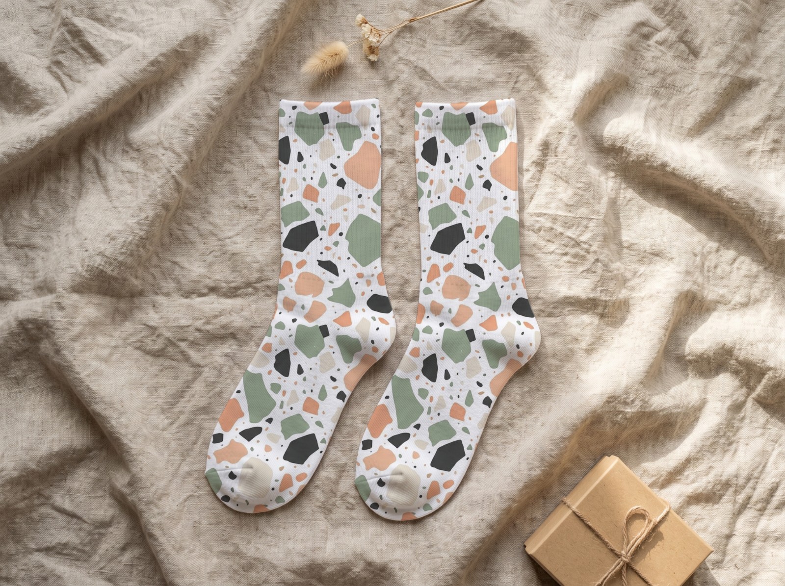 White Crew Socks Pair Flat Lay on Linen showing a pastel terrazzo pattern