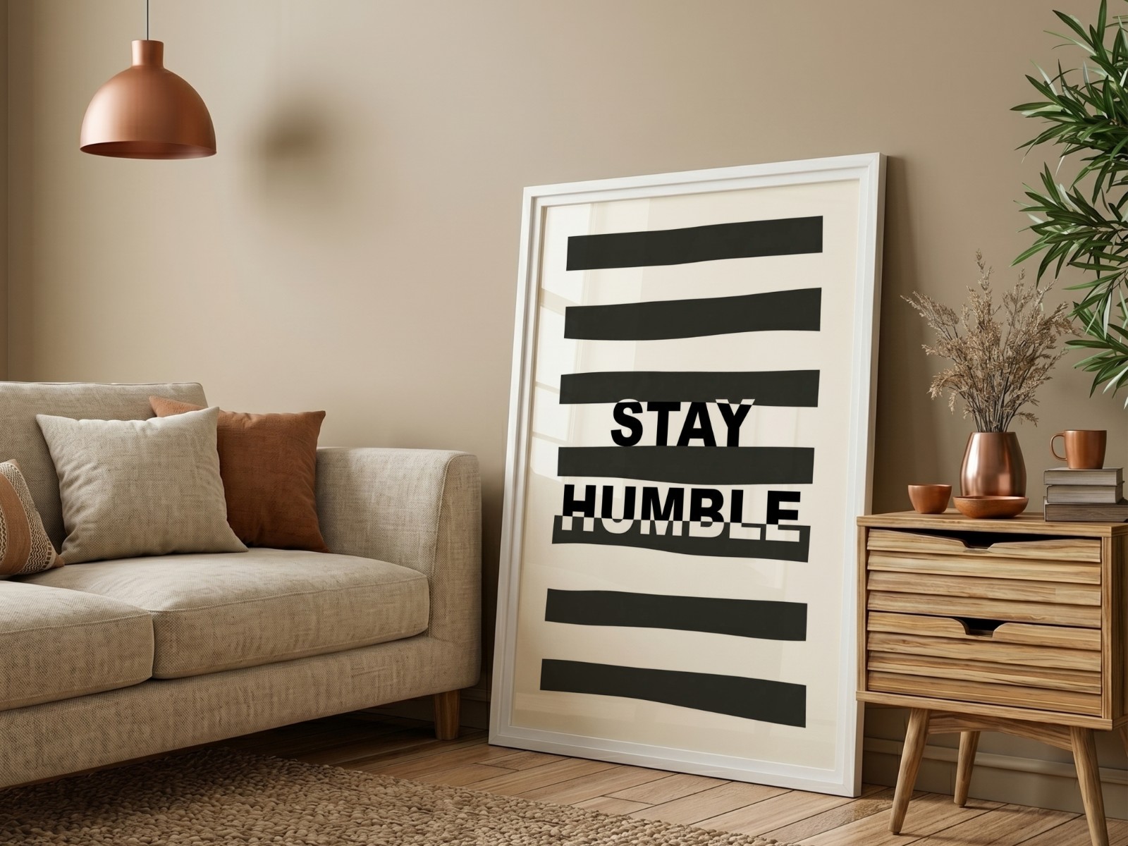 White Frame on Beige Wall with Sofa showing a Stay Humble typography print