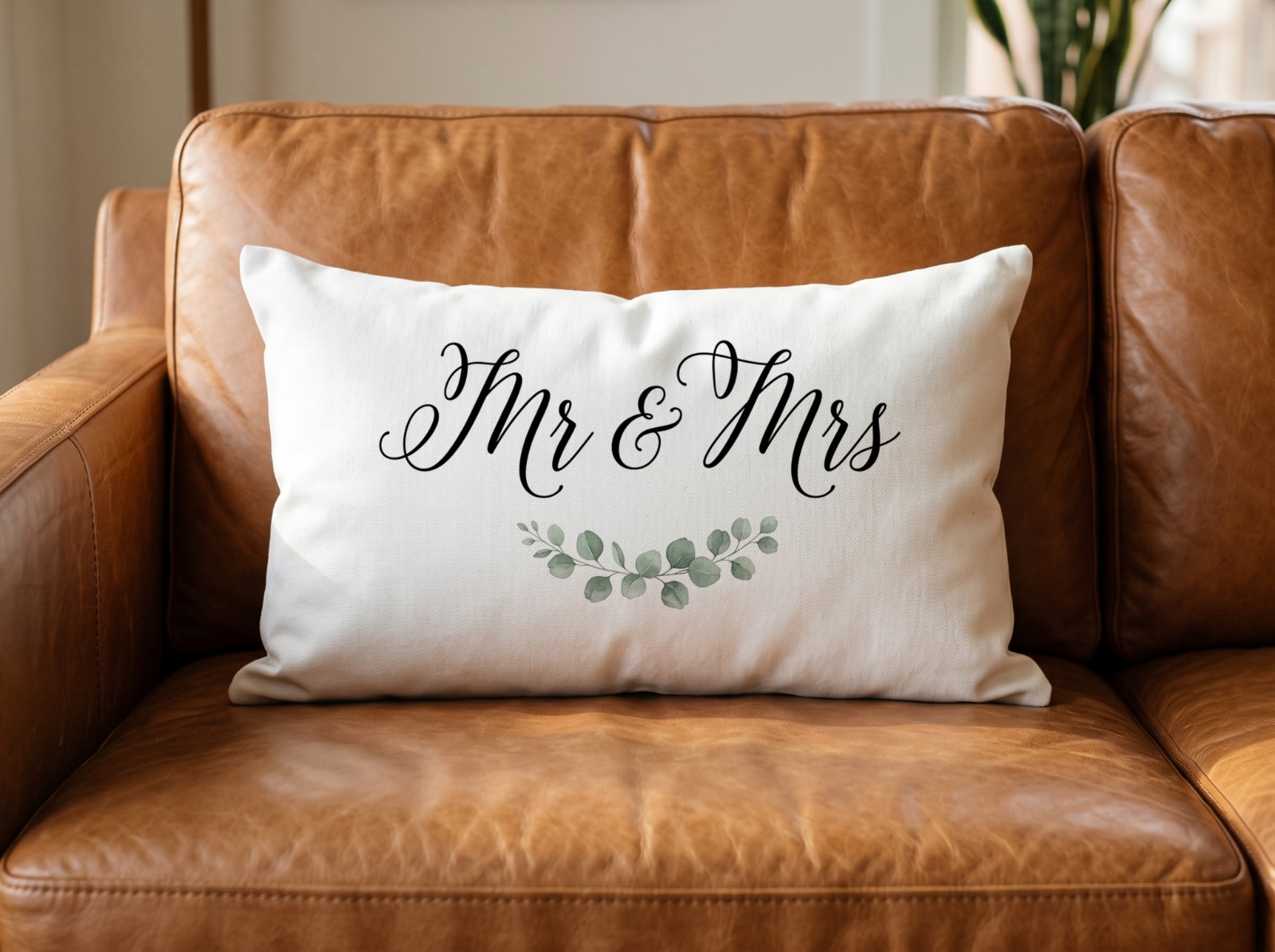 White Lumbar Pillow on a Leather Sofa in Warm Light showing a Mr & Mrs wedding lettering