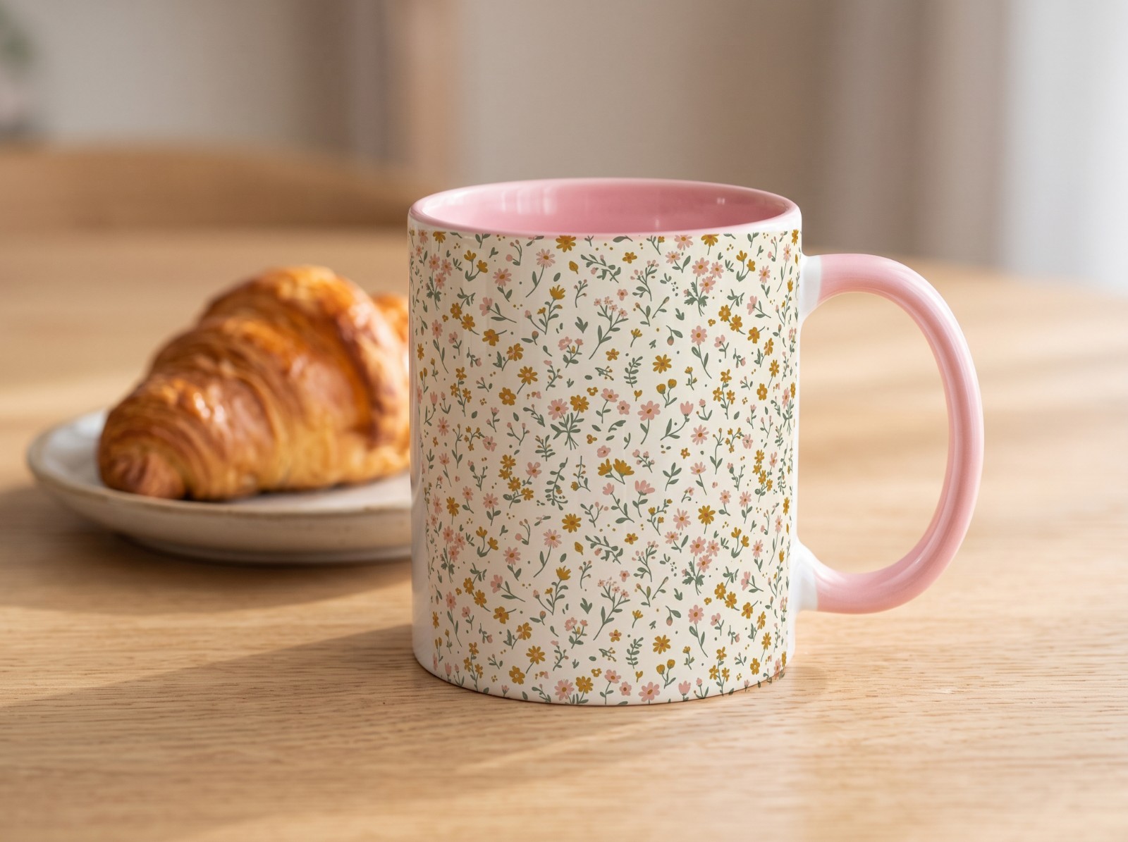 Pink Accent Mug on an Oak Table with a Croissant showing a ditsy wildflower pattern