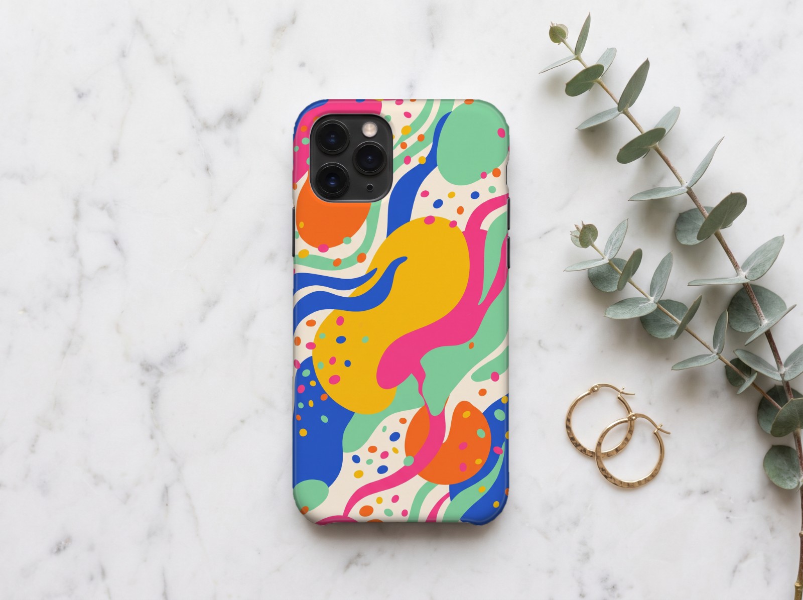 White Phone Case on Marble with Eucalyptus showing a bold colourful abstract pattern