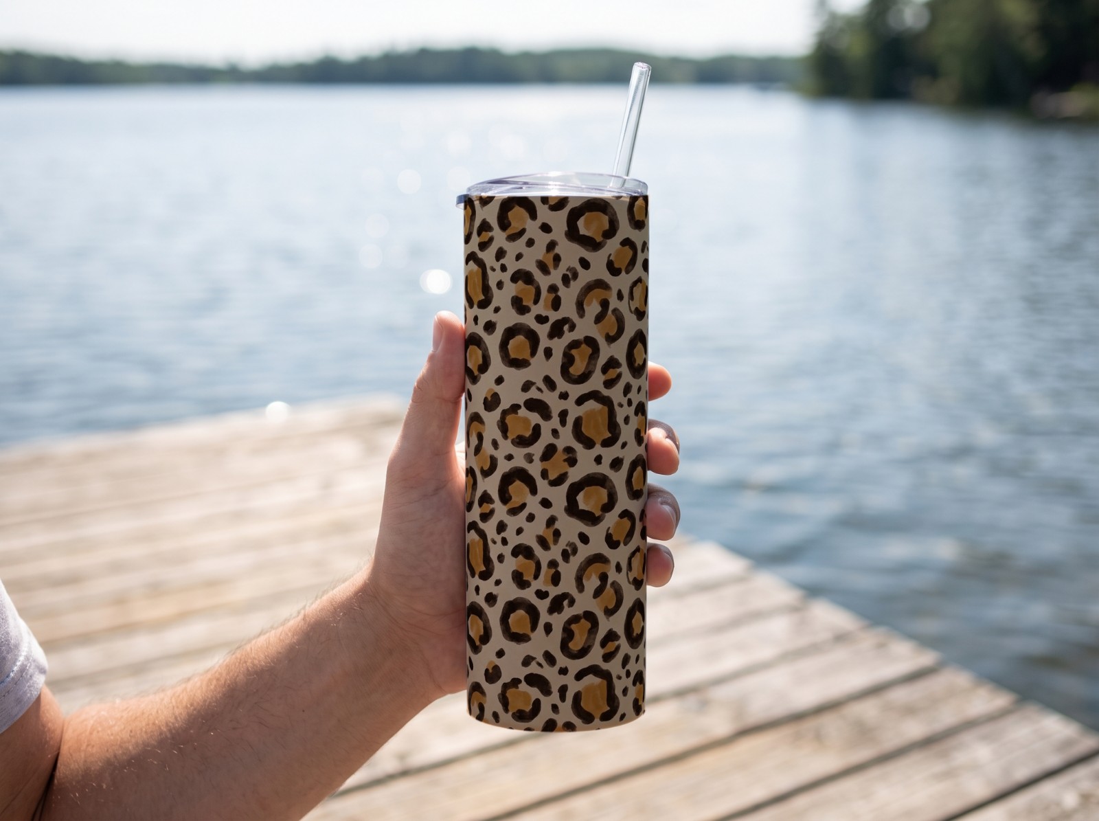 White Skinny Tumbler Held in a Hand on a Lake Dock showing a neutral leopard print