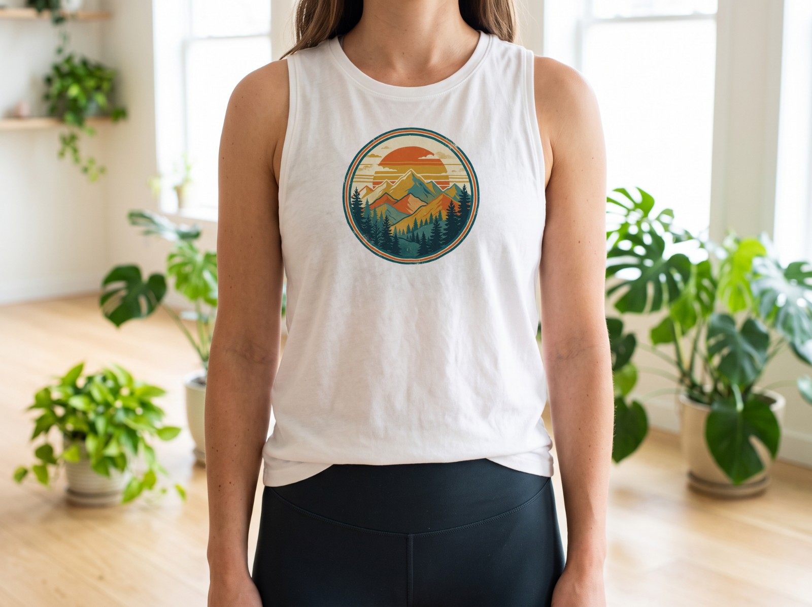 White Tank Top on a Woman in a Bright Yoga Studio showing a retro mountain sunset badge