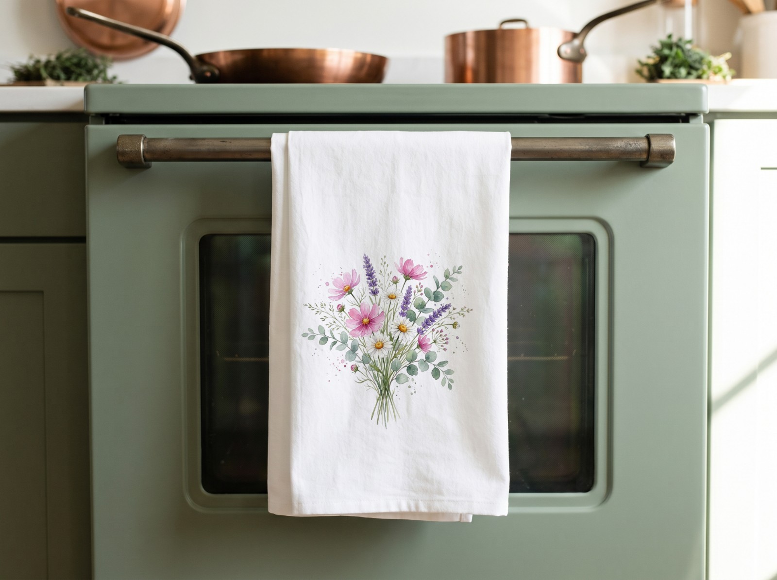 White Tea Towel Hanging on a Sage Green Oven showing a watercolour wildflower bouquet