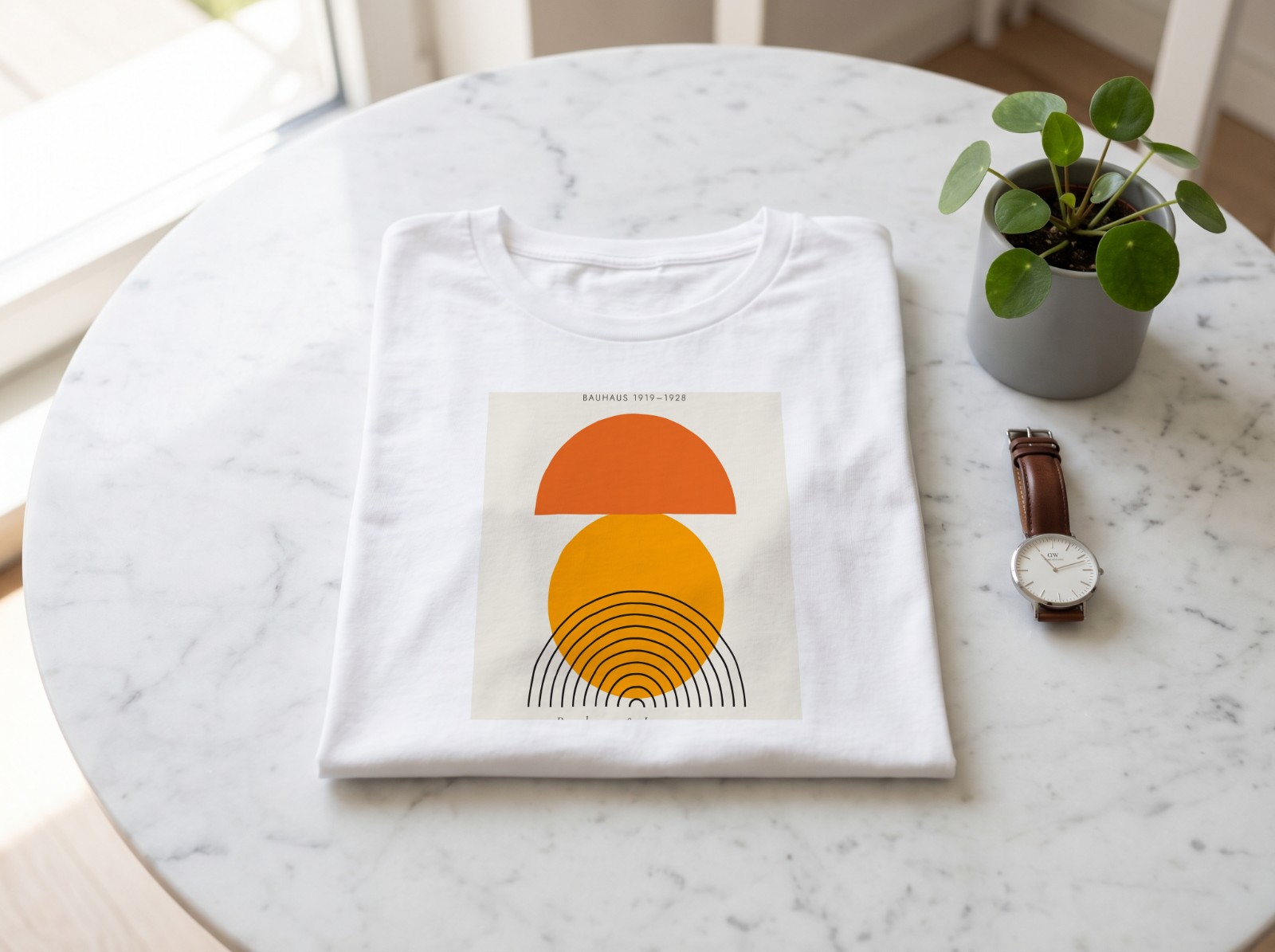 Folded White T-Shirt on a Marble Table showing a Bauhaus sun print