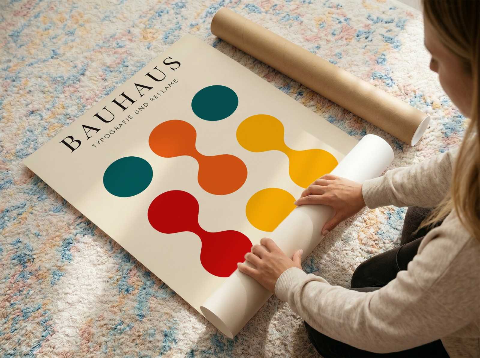 Woman Unrolling Poster on Colourful Rug showing a Bauhaus circles print