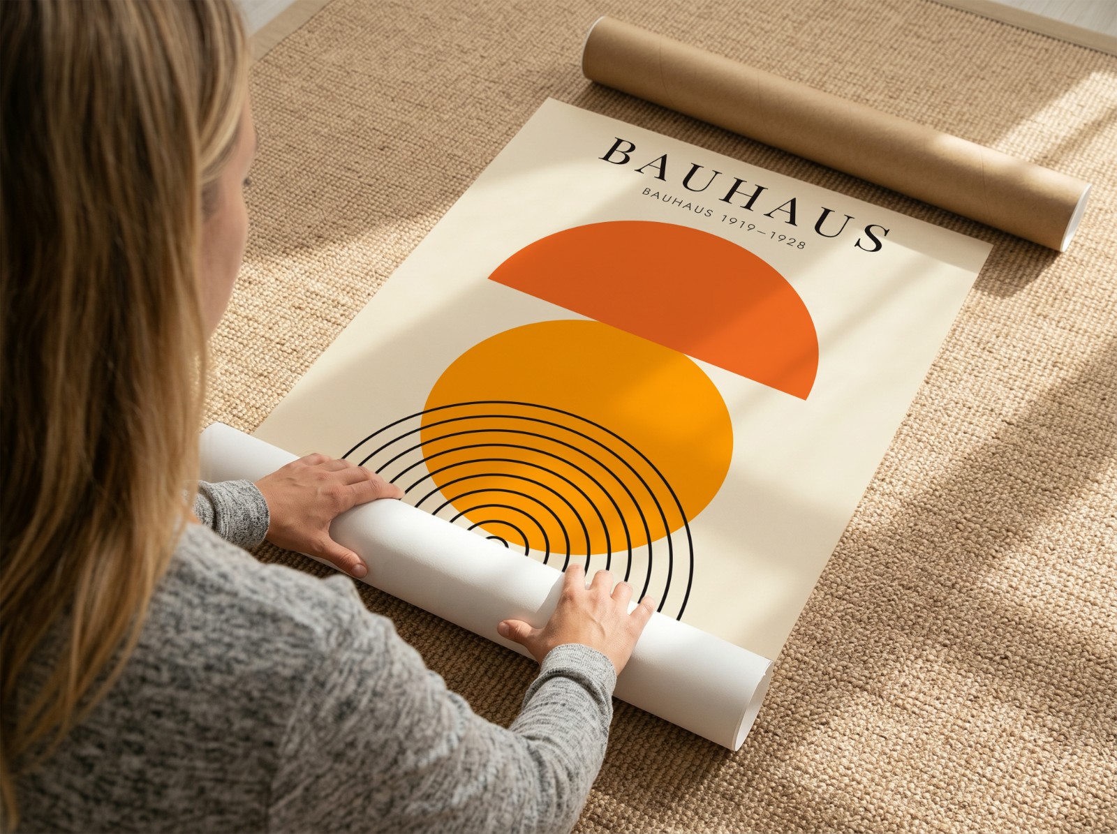 Woman Unrolling Poster on Jute Rug showing a Bauhaus sun print