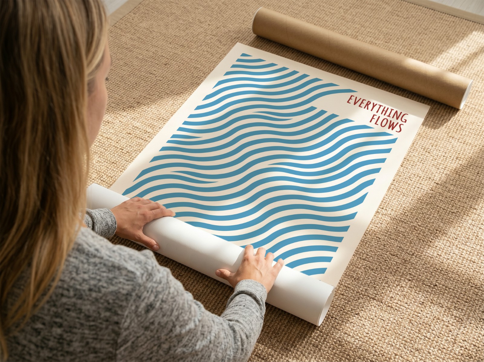 Woman Unrolling Poster on Jute Rug showing an Everything Flows wave print