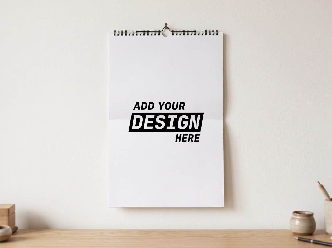 Wall Calendar Mockup Hanging on a White Wall Above a Desk